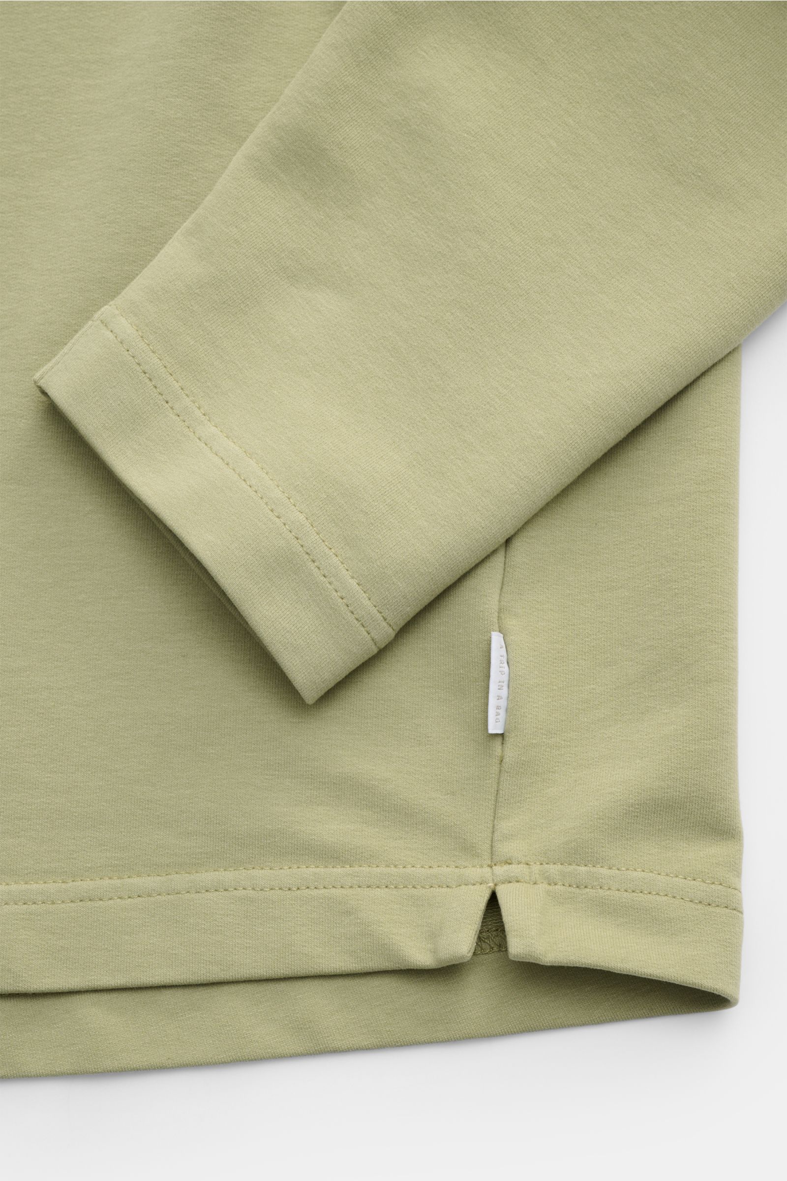 04651/ A trip in a bag Rundhals-Longsleeve 'If Tee' salbei in Nahaufnahme von Ärmel und Saum, Jersey Baumwolle, Oversized Fit, Weblabel seitlich.