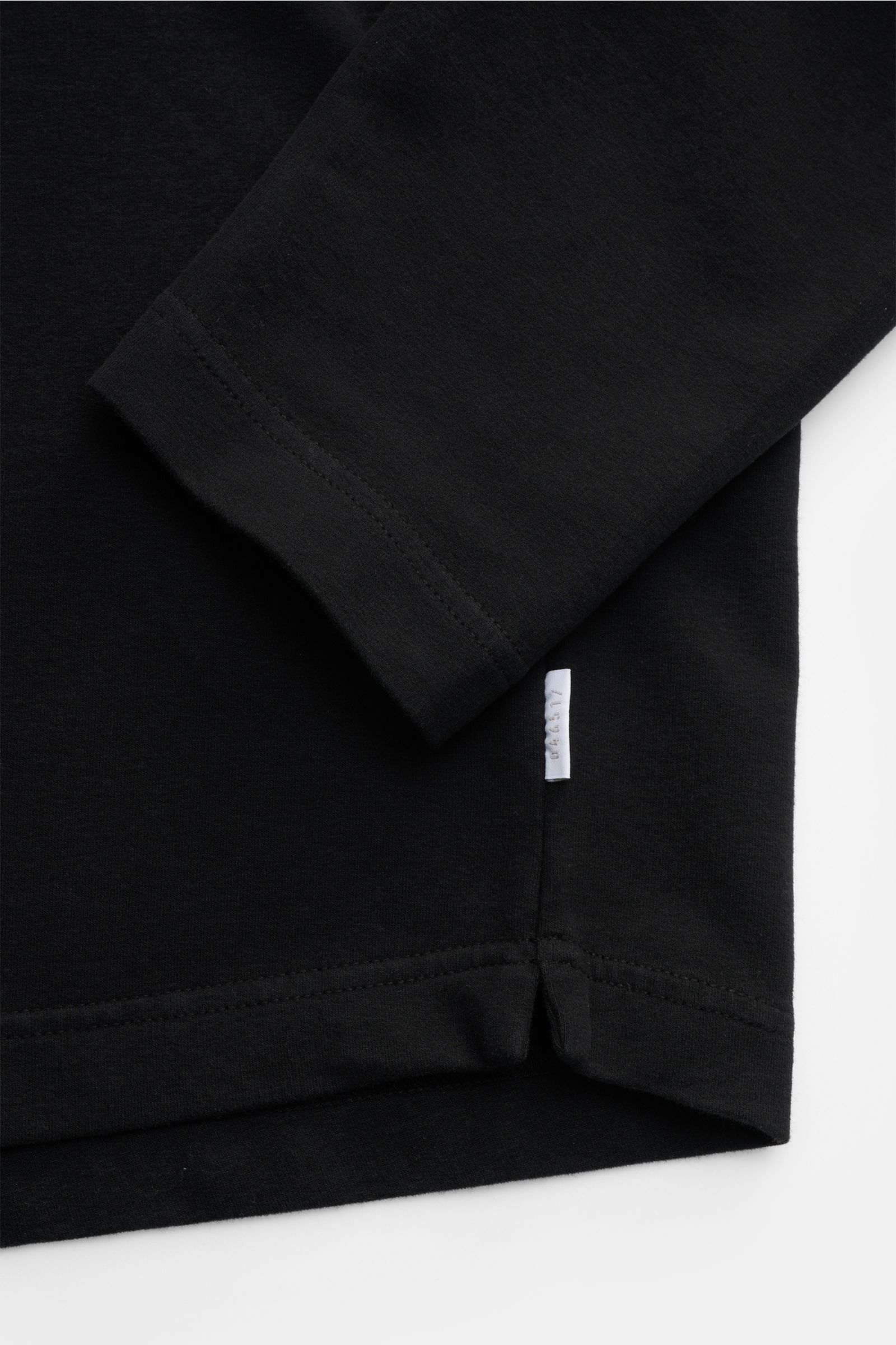 04651/ A trip in a bag Rundhals-Longsleeve 'If Tee' schwarz, Detailaufnahme von Ärmel und Saum, Jersey aus elastischer Baumwolle, weicher Griff, Oversized Fit, Weblabel in Seitennaht.