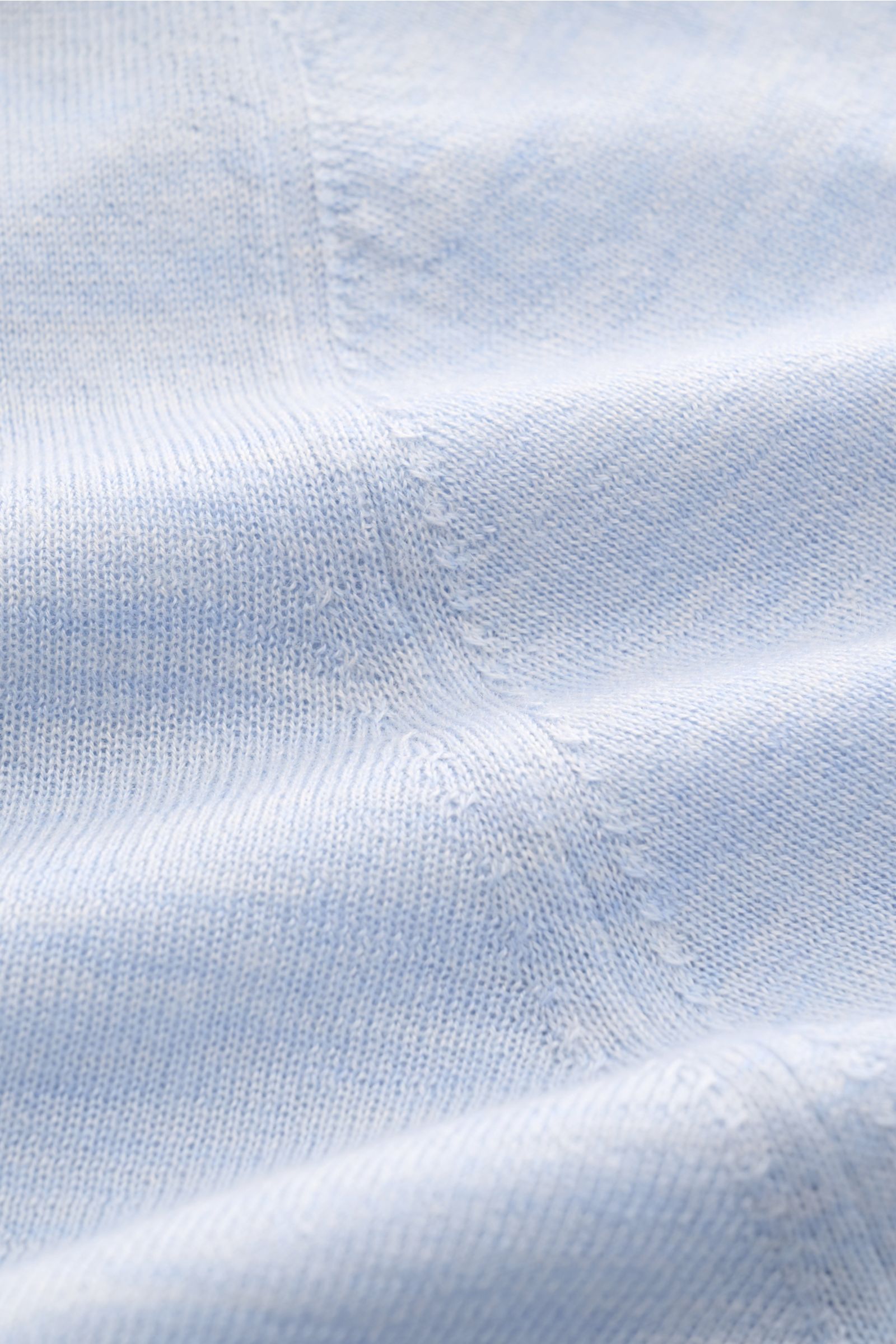 Close-up front view of the fine knit texture and stitching of the Filippo de Laurentiis Crew neck jumper pastel blue mottled, showing its soft silk-cashmere blend fabric.

Summery knitwear: With this jumper in a fine silk-cashmere blend, FILIPPO DE LAU