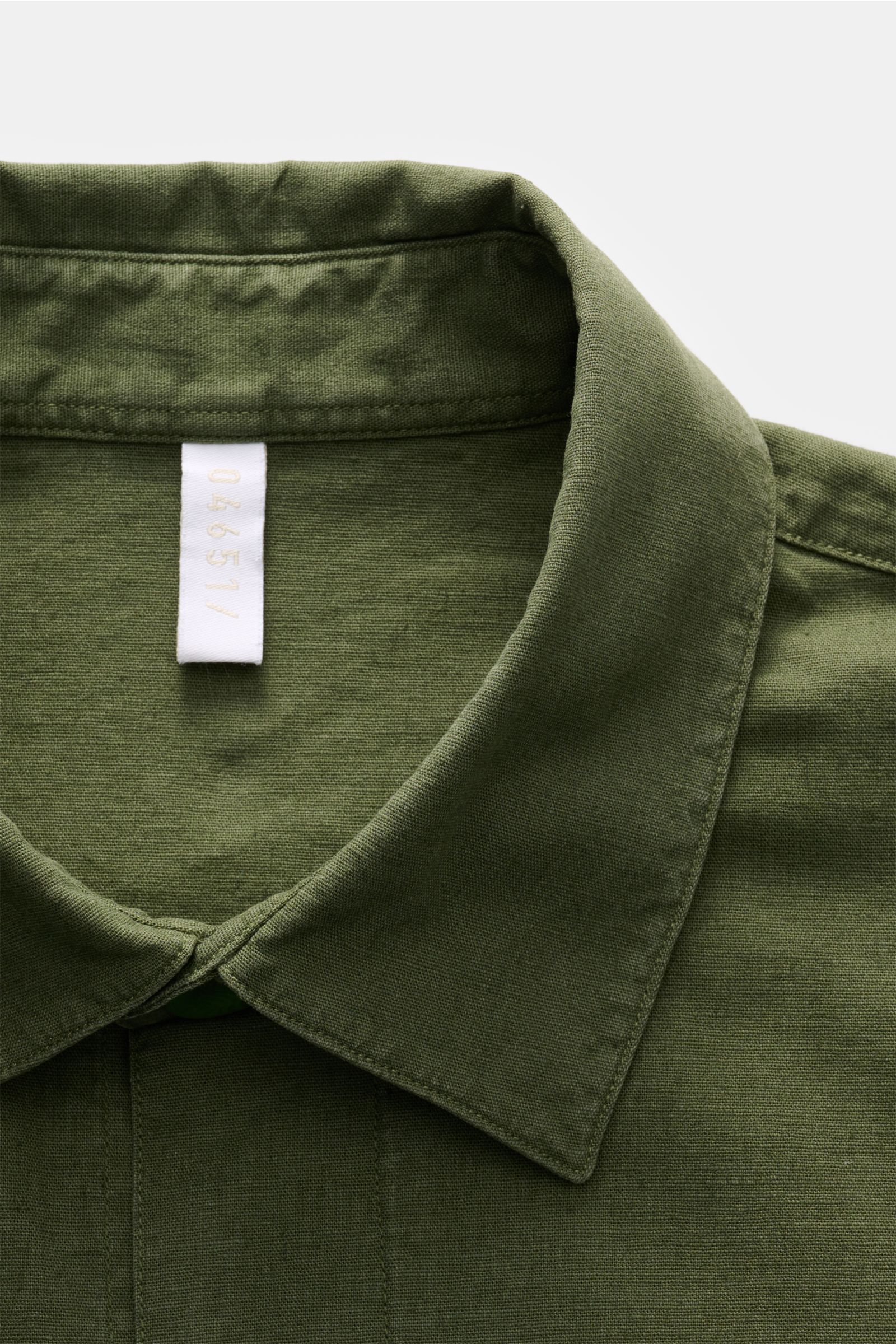 Close-up front view of the collar and top button area of the 04651/ A trip in a bag Overshirt 'Linen Travel' navy, a lightweight linen-cotton blend overshirt perfect for transitional seasons with patch pockets and a six-button placket.

The lightweig