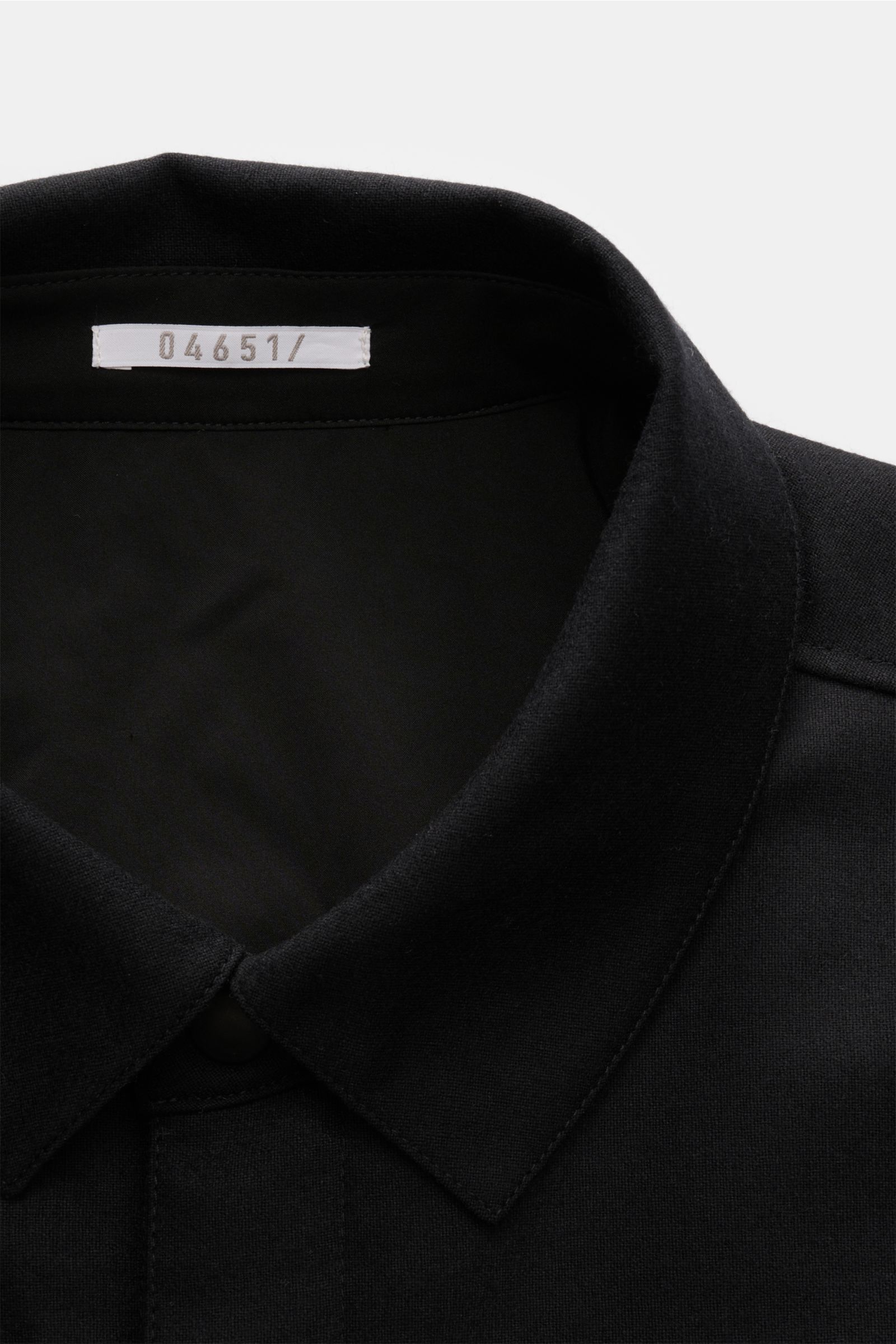 Close-up front view of the collar and snap button placket of the 04651/ A trip in a bag Reversible overshirt black, made from a blend of wool, cashmere, and premium-quality microfibre, featuring reversible design, soft/smooth feel, slight stretch content,