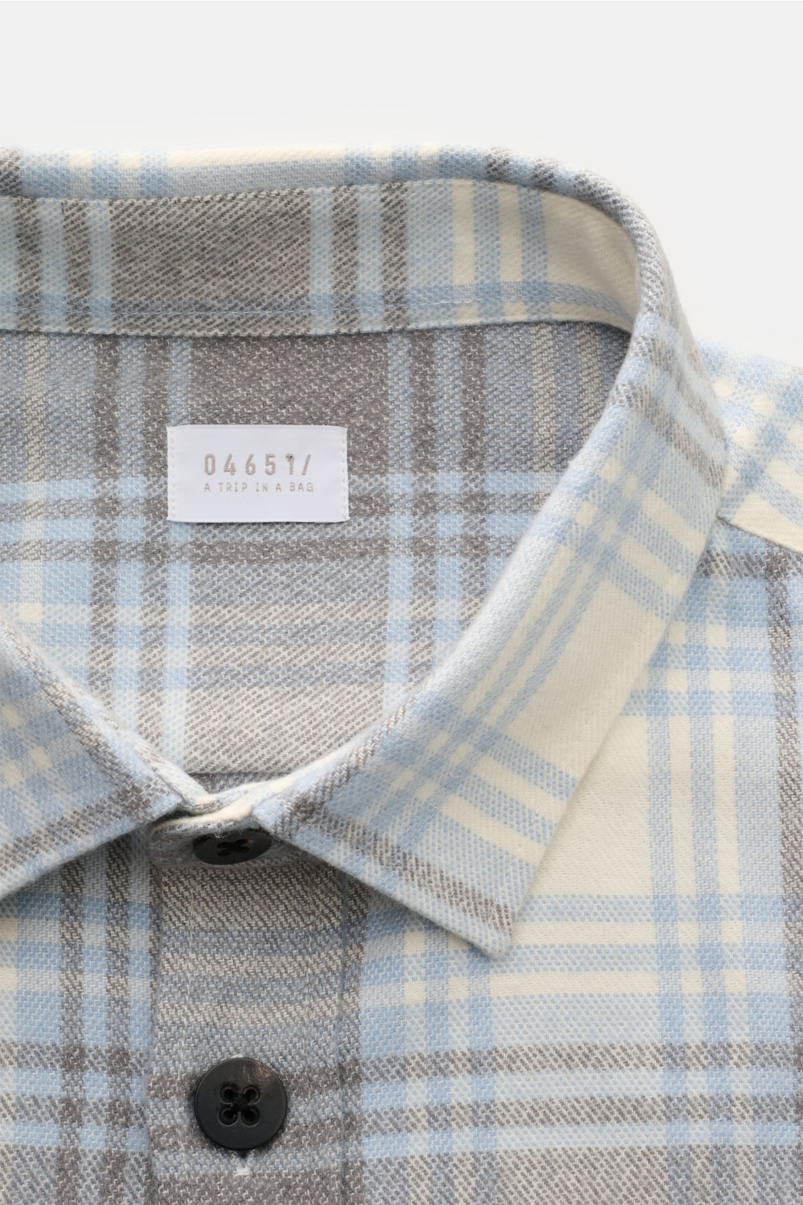 Close-up front view of the 04651/ A trip in a bag Overshirt 'Check Overshirt' off-white/light blue/grey checked, showing the turn-down collar, six-button placket, and soft pure cotton in a modern checked pattern. Stay casual through the transitional perio