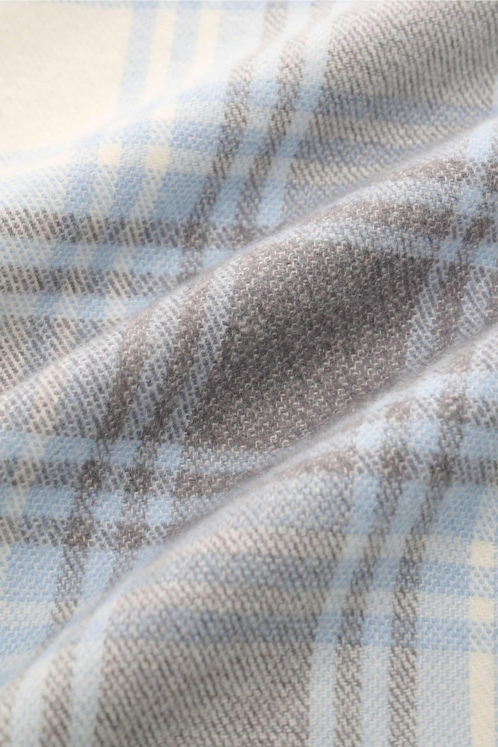 Close-up front view of the 04651/ A trip in a bag Overshirt 'Check Overshirt' off-white/light blue/grey checked flannel fabric, showing soft pure cotton texture and modern checked pattern. Stay casual through the transitional period: This overshirt in fla