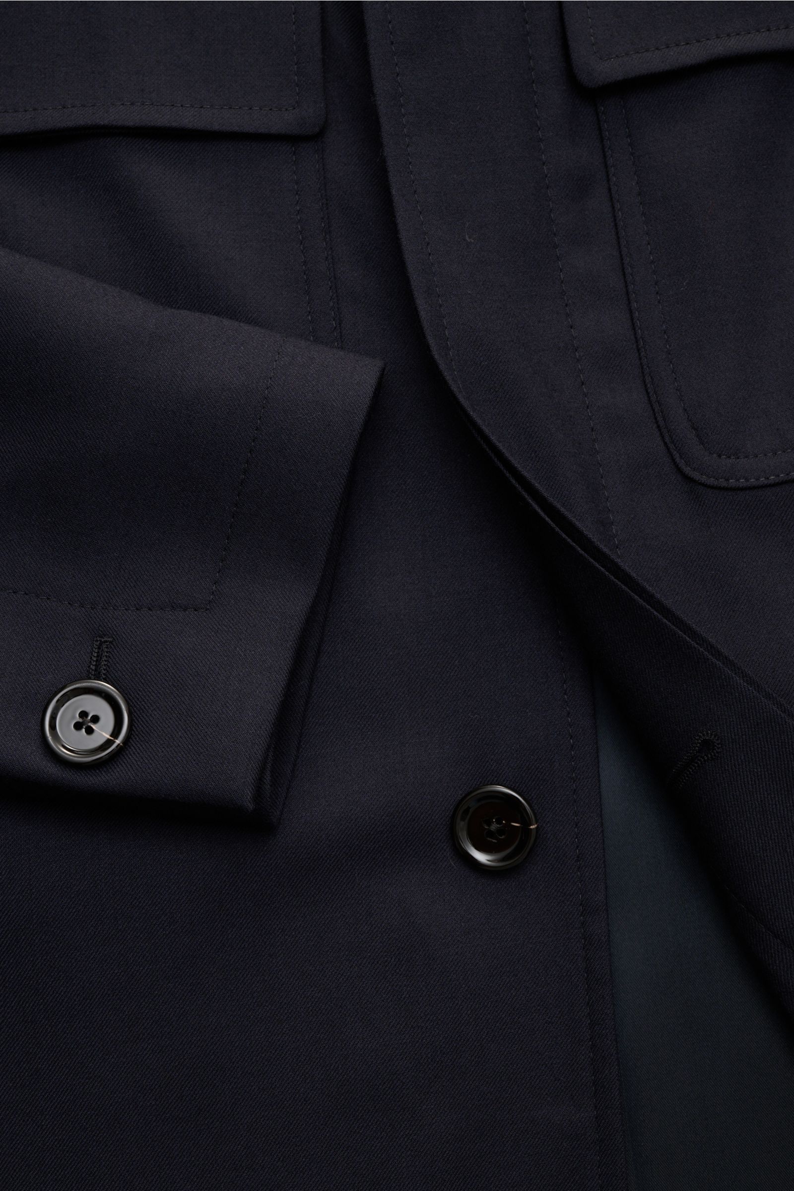 Close-up image from a top-down perspective showing the cuff, buttons, and chest pocket of the Lardini Woll-Overshirt 'Aaansel' navy, made from lightly elastic pure virgin wool flannel with a soft feel, regular fit, turn-down collar, concealed five-button 