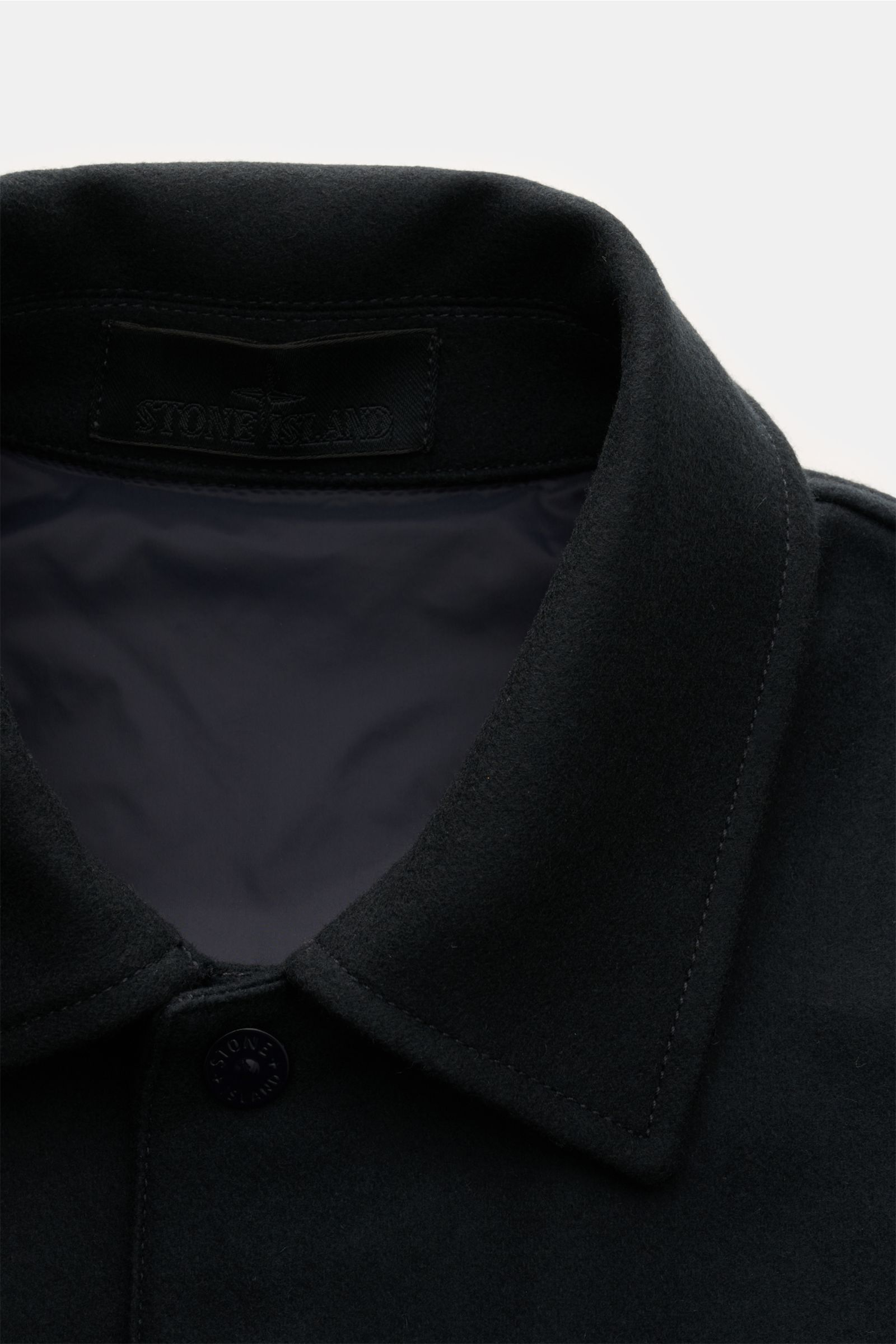Stone Island Flannel overshirt 'Ghost Piece' dark navy close-up from above showing turn-down collar, snap button placket, and interior lining. 

Pared down to the essentials but unmistakably STONE ISLAND: This overshirt from the 'Ghost Collection' comb
