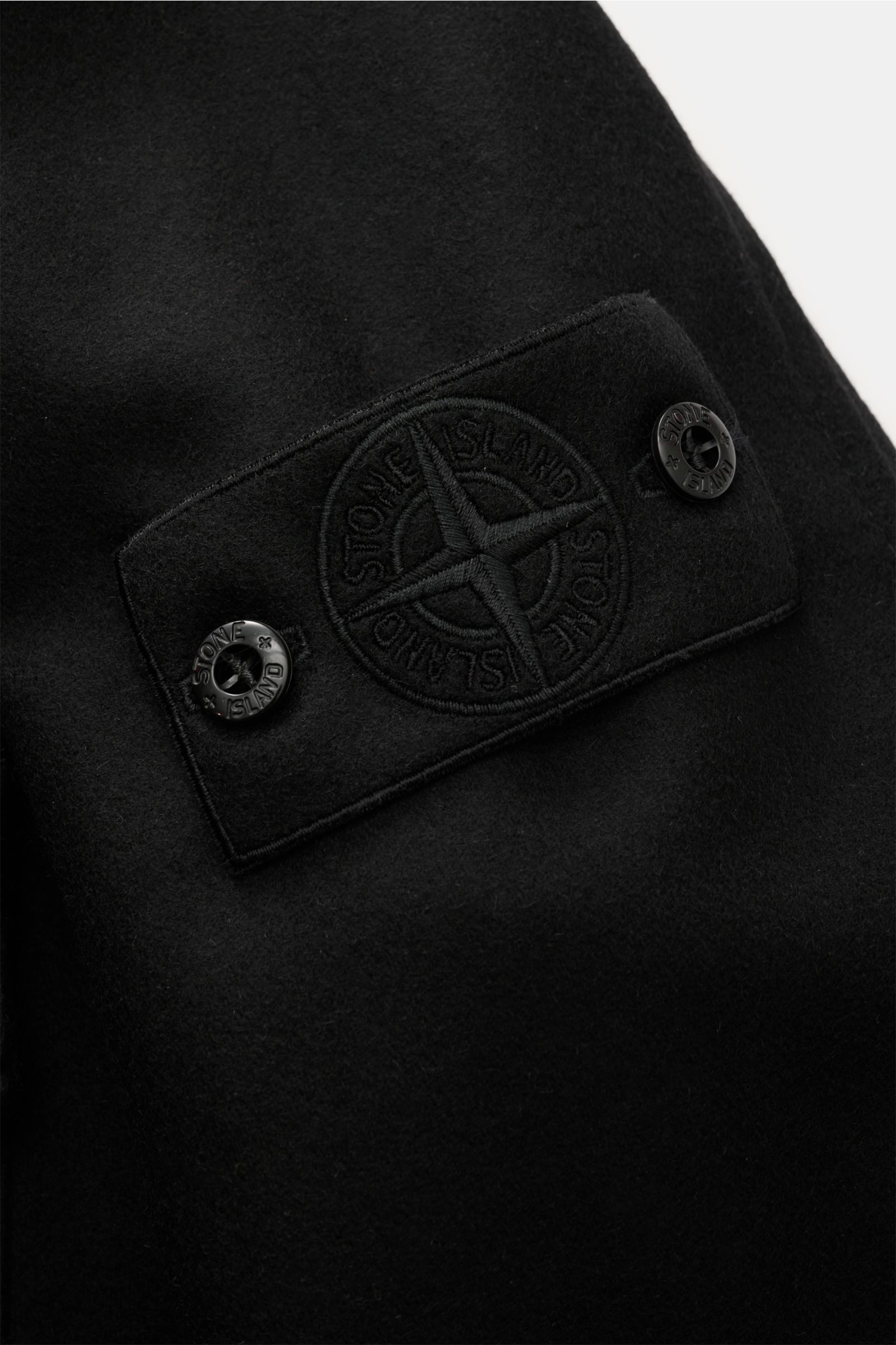 Stone Island Flanell-Overshirt 'Ghost Piece' schwarz, Detailaufnahme Ärmel mit tonalem Kompass-Badge und Druckknöpfen aus Wolle-Microfaser.