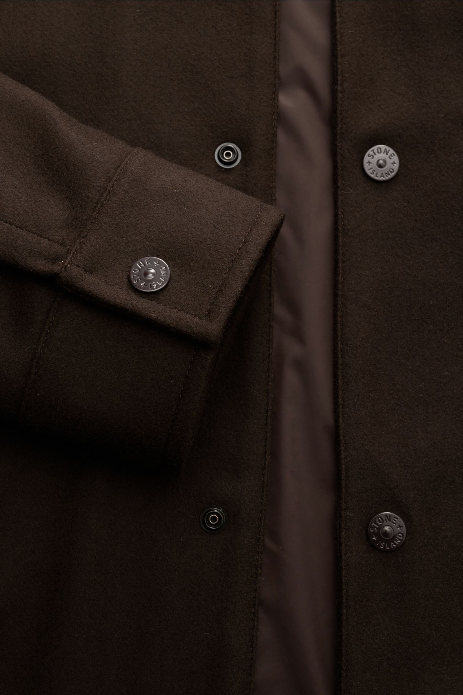 Close-up front view of Stone Island Flanell-Overshirt 'Ghost Piece' dunkelbraun showing wool-microfiber fabric, snap buttons, cuff, and tonal lining.  

Reduziert auf das Wesentliche und dabei unverkennbar STONE ISLAND: Dieses Overshirt aus der 'Ghost 