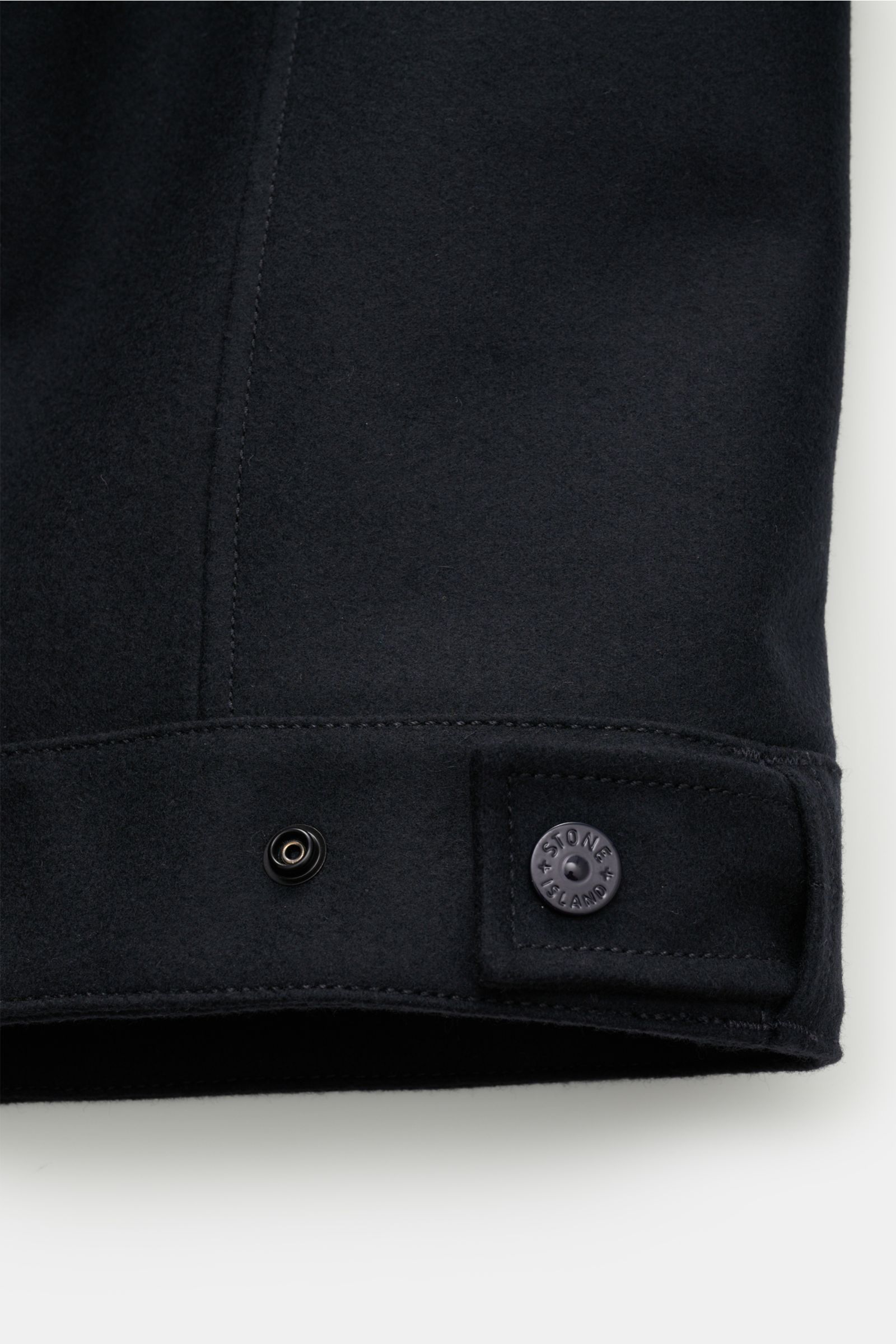 Alt tag (125 characters max): Close-up of Stone Island Overshirt 'Ghost Piece' dark navy cuff with monochrome logo button, wool blend fabric texture.

Description: This overshirt by STONE ISLAND in a felted wool blend with a firm feel has an attractive
