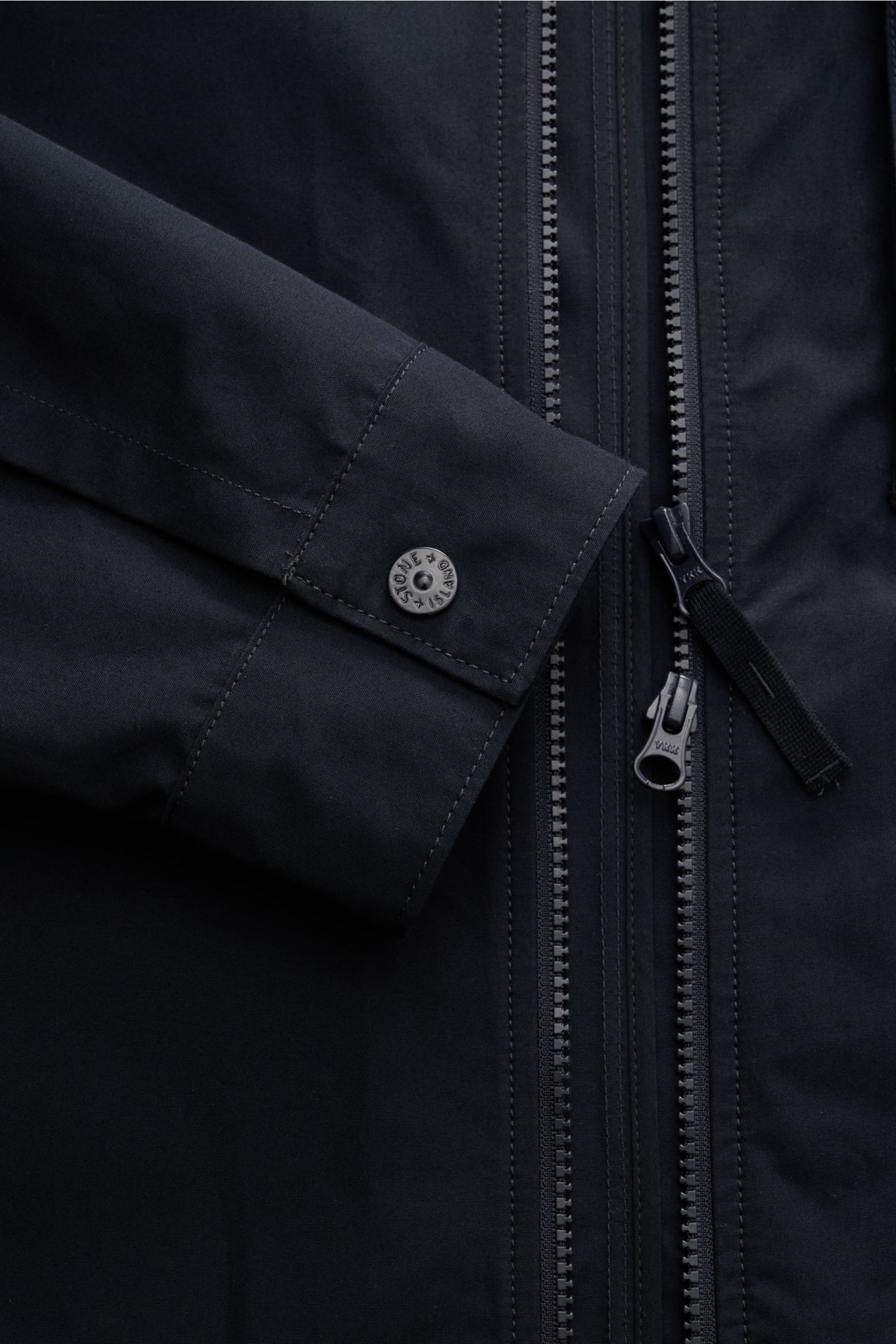 Close-up front view of Stone Island Overshirt 'Weather Proof Cotton Canvas Ghost Piece' navy, showing cuff with snap button and two-way zip, tonal logo badge visible. Get the best casual look for autumn with the overshirt 'Weather Proof Cotton Canvas' fro