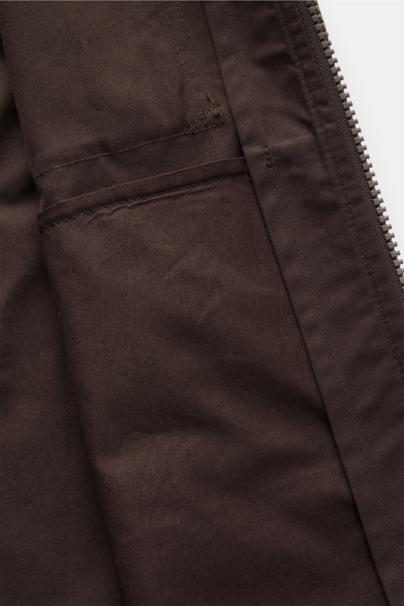 Nahaufnahme des Stone Island Overshirts 'Weather Proof Cotton Canvas Ghost Piece' dunkelbraun, von innen mit sichtbarer Brusttasche, Reißverschluss und Baumwoll-Canvas.