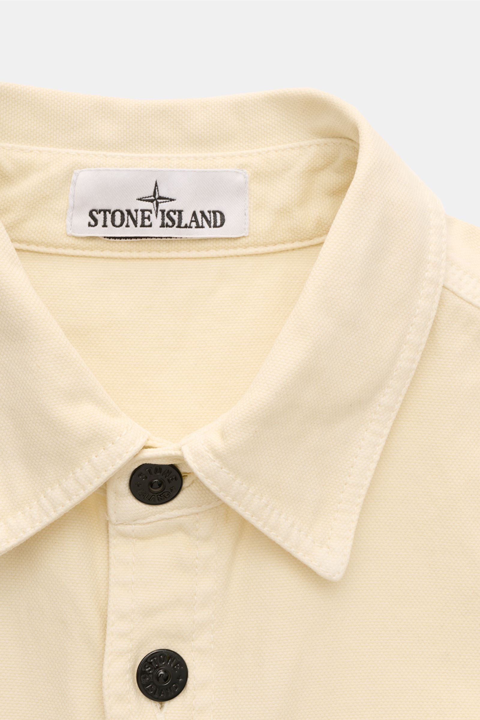 Stone Island Overshirt 'Organic Panama' creme, Slim Fit, reine Baumwolle, Umlegekragen, Sechs-Knopf-Leiste, Detailansicht Kragen frontal.