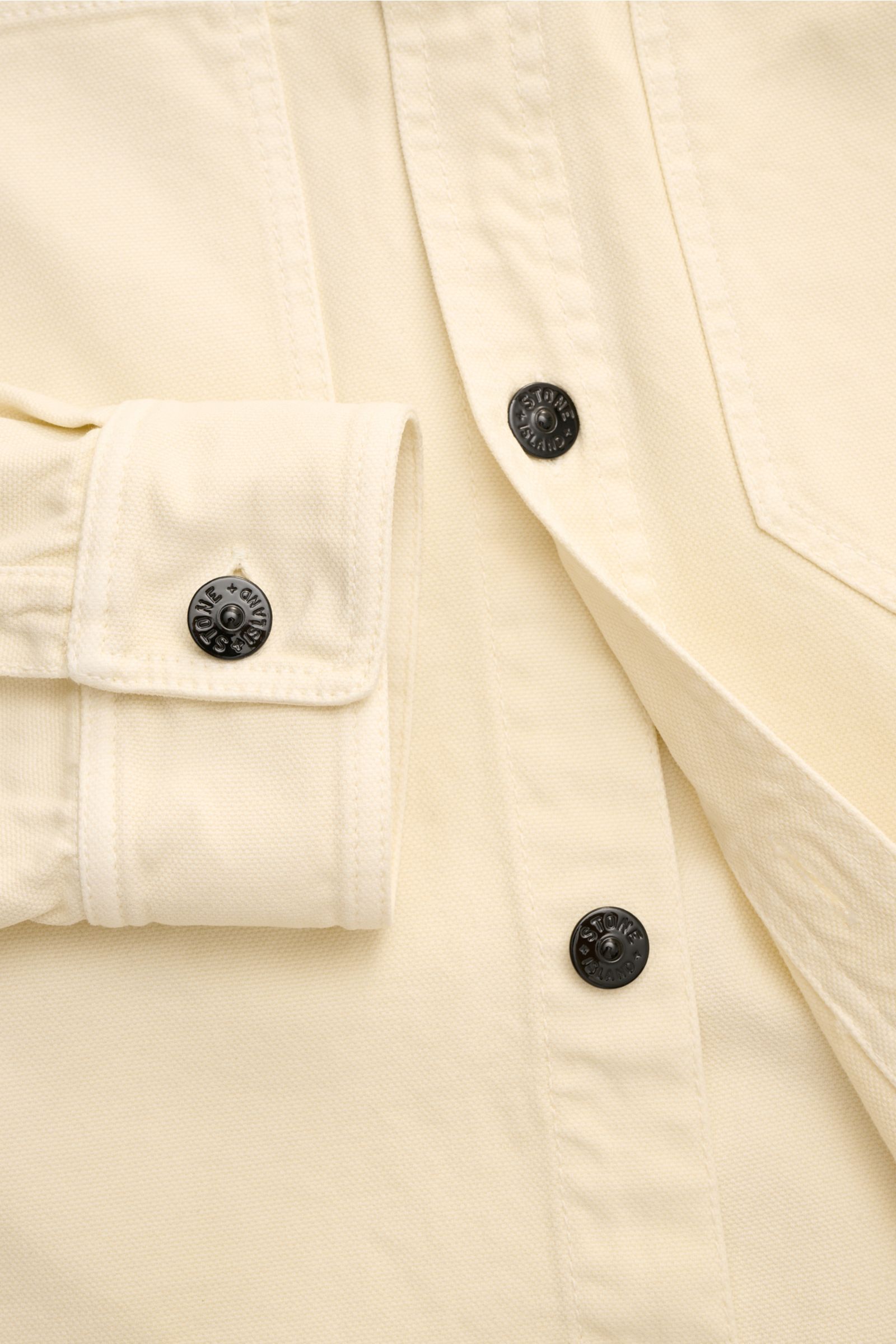 Nahaufnahme des Stone Island Overshirt 'Organic Panama' creme aus reiner Baumwolle mit Slim Fit, Manschetten und sechs Knöpfen.