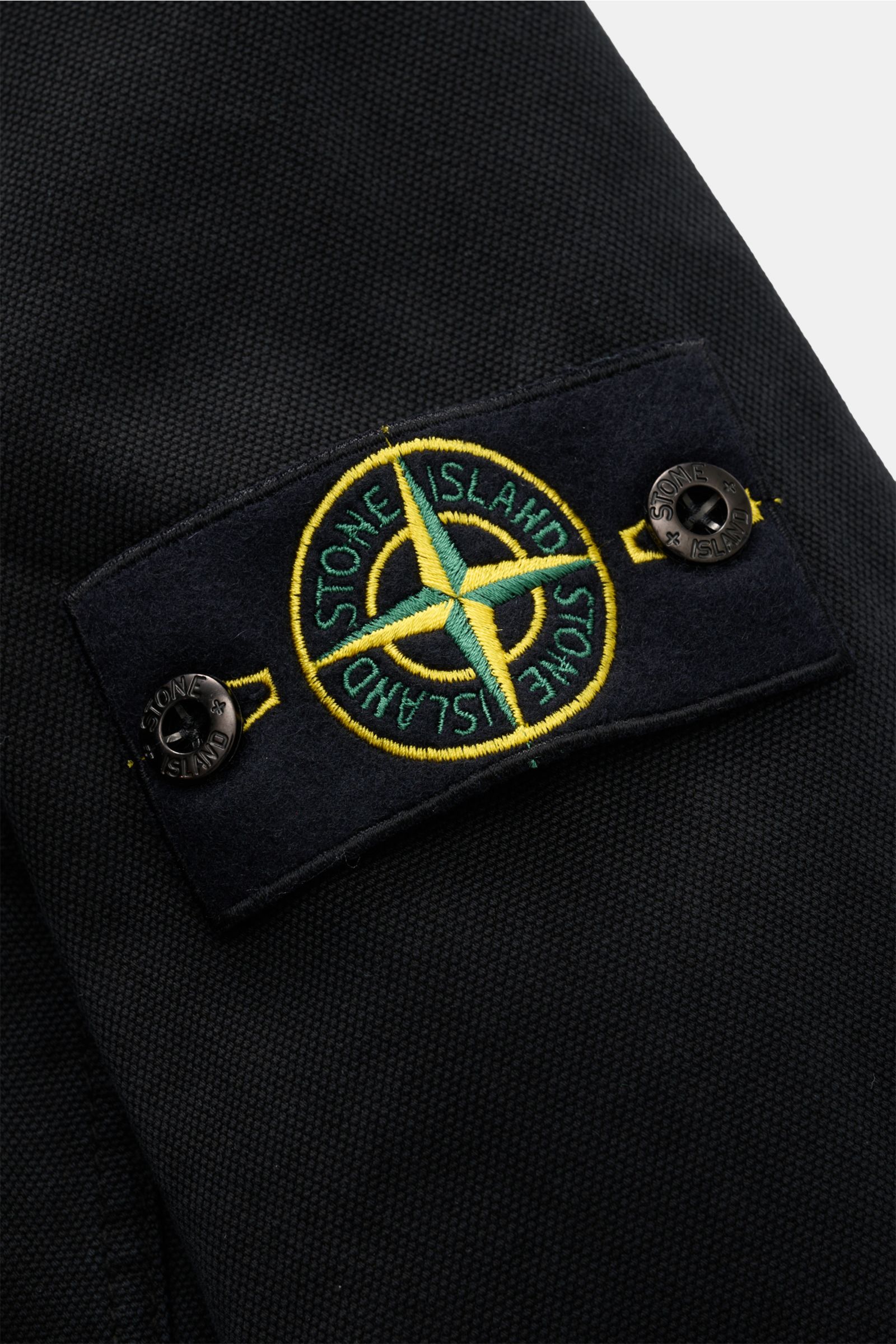 Nahaufnahme des schwarzen Stone Island Overshirt 'Organic Panama' Ärmel mit Kompass-Badge aus reiner Baumwolle, weicher Griff.