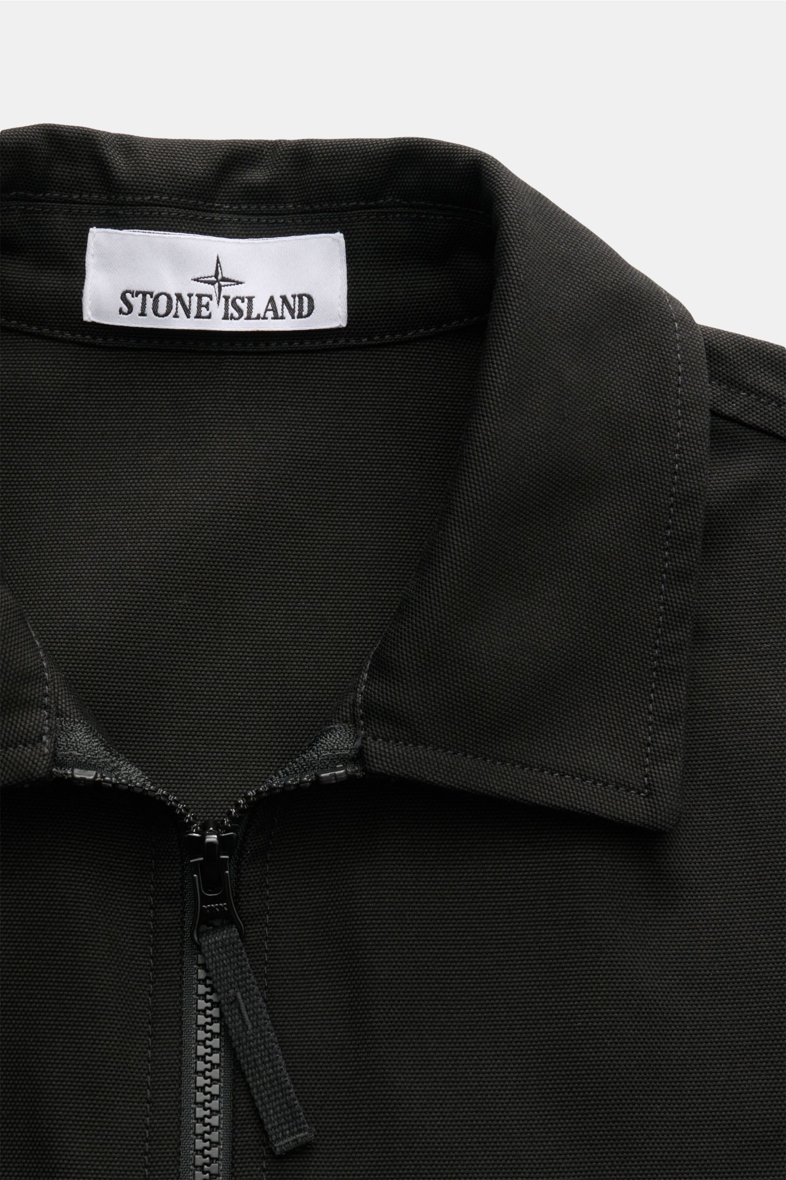 Close-up front view of Stone Island Overshirt 'Panama Cotton' schwarz, featuring a cotton canvas fabric, garment dyed, slim fit with a two-way zipper and fold-over collar. 

Robustes Overshirt: Dieser Hybrid in typischer STONE ISLAND-Manier ist aus Bau