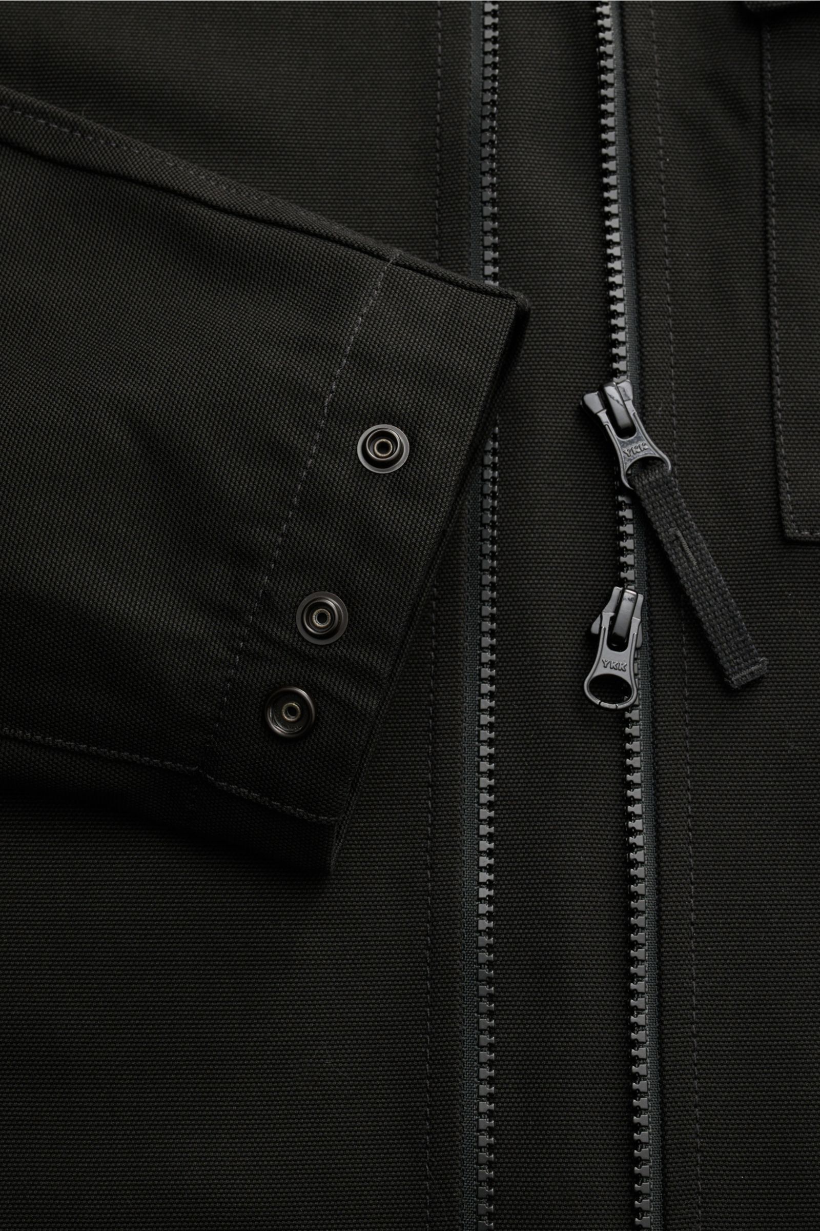 Close-up front view of the Stone Island Overshirt 'Panama Cotton' schwarz showing black cotton canvas fabric, two-way YKK zipper, and snap button cuff.  

Robustes Overshirt: Dieser Hybrid in typischer STONE ISLAND-Manier ist aus Baumwoll-Canvas gefert