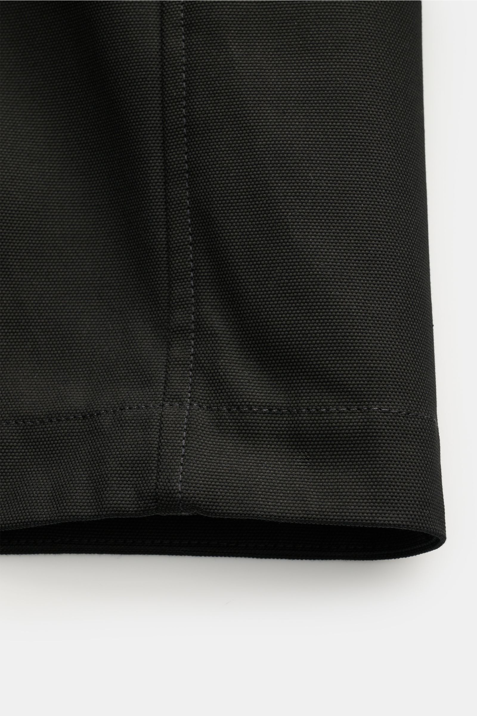 Close-up front view of the hem and stitching on the black Stone Island Overshirt 'Panama Cotton' schwarz, made from robust pure cotton canvas with a firm, textured feel. Robustes Overshirt: Dieser Hybrid in typischer STONE ISLAND-Manier ist aus Baumwoll-C