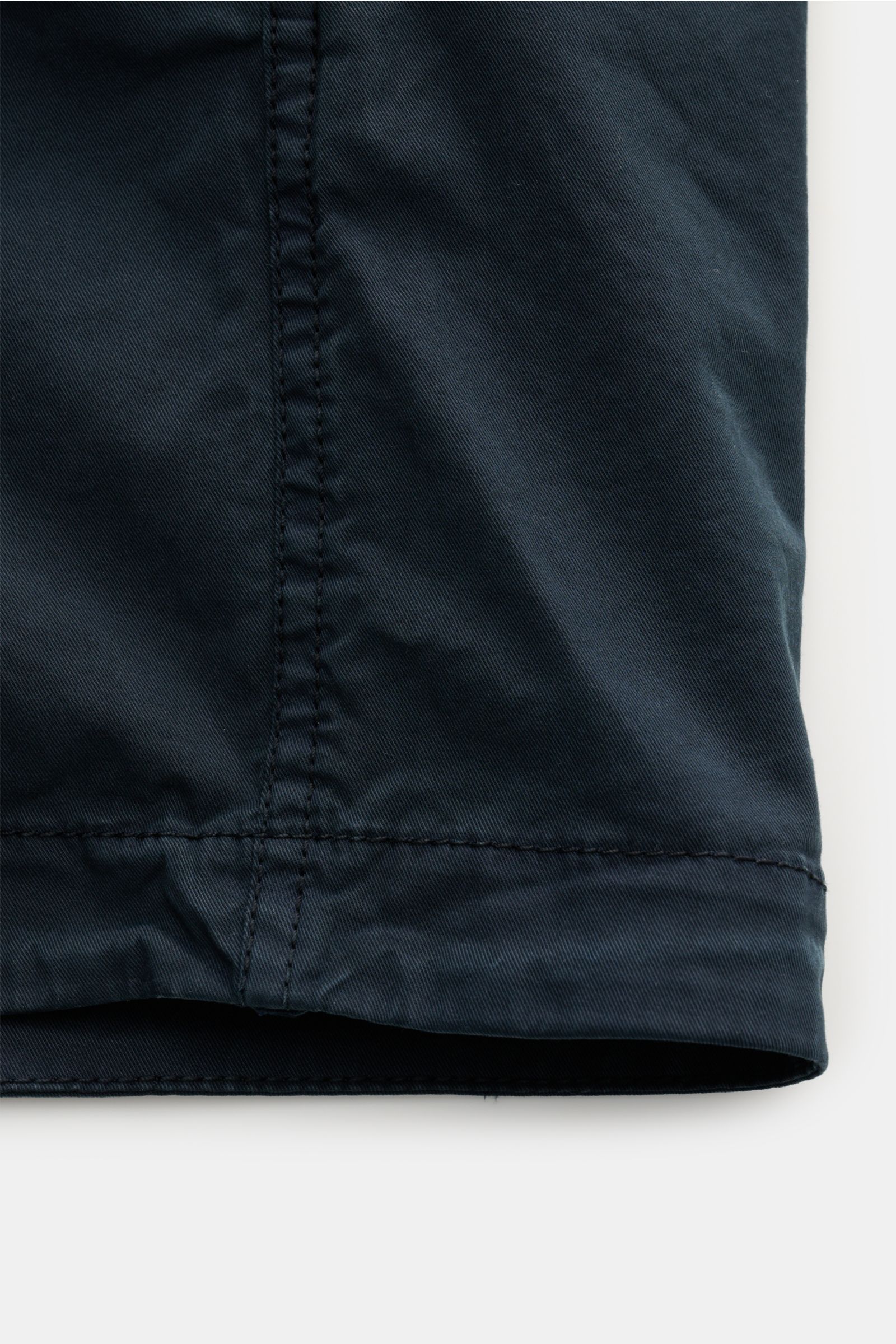 Nahaufnahme des Saums des Stone Island Overshirt navy aus twill reiner Baumwolle, elastisch, weich, leicht, garment dyed, Slim Fit, mit Umlegekragen, Zwei-Wege-Reißverschluss, Brusttasche mit Zipper, Kompass-Badge am Ärmel und regulierbaren Ärmelabschlüss