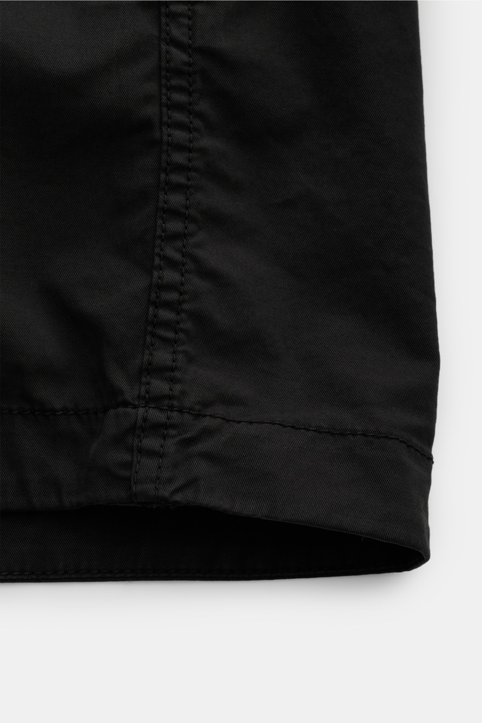 Close-up front view of the Stone Island Overshirt schwarz showing twill aus reiner Baumwolle, elastische Qualität, weicher Griff, very leichte Qualität, garment dyed, Slim Fit, Zwei-Wege-Reißverschluss, Umlegekragen, Brusttasche mit Zipper, typisches Komp