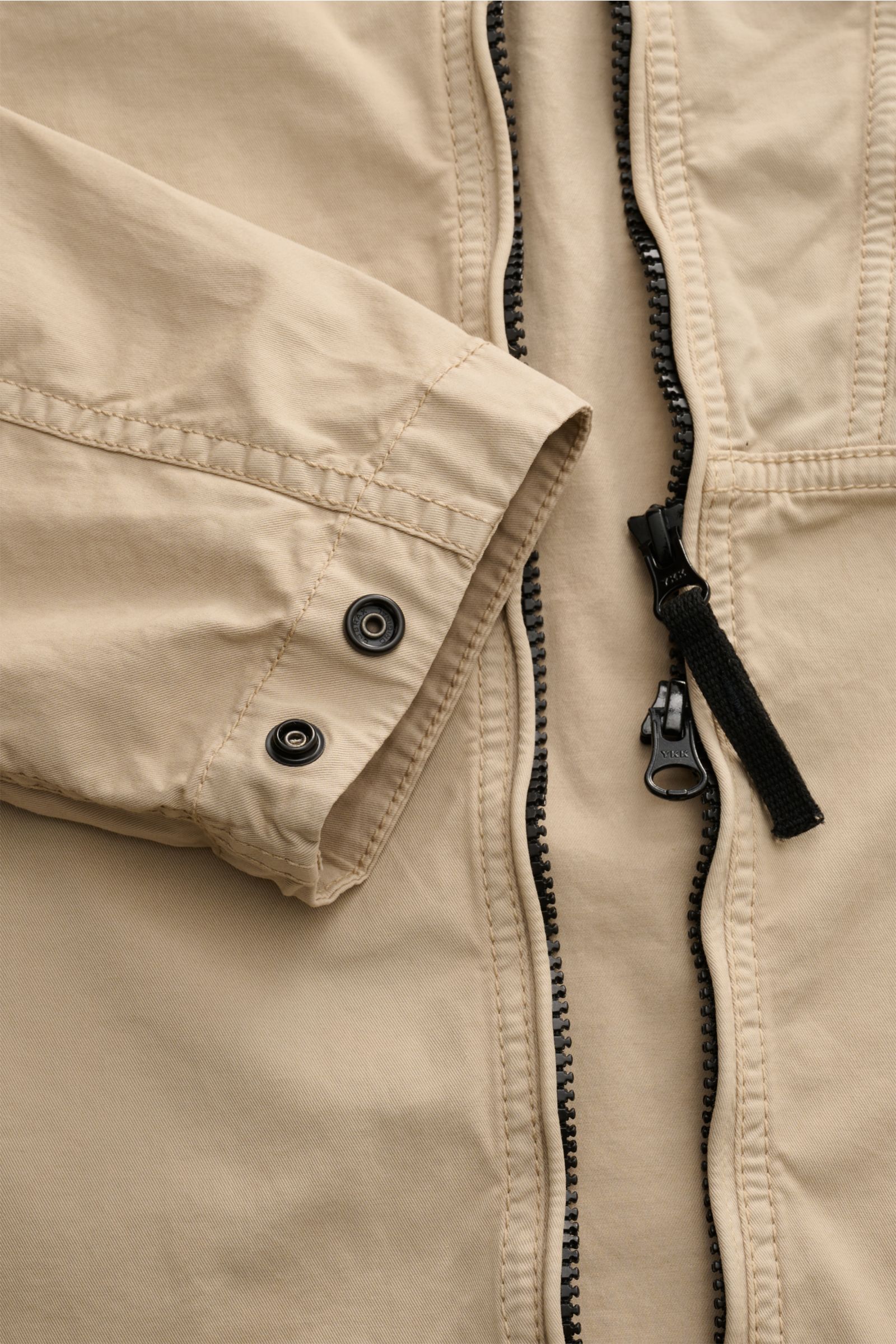 Stone Island Overshirt beige in Nahaufnahme von oben, Twill Baumwolle, elastisch, weich, leicht, garment dyed, Slim Fit, 2-Wege-Reißverschluss, Umlegekragen, Brusttasche, Kompass-Badge, regulierbare Ärmel.