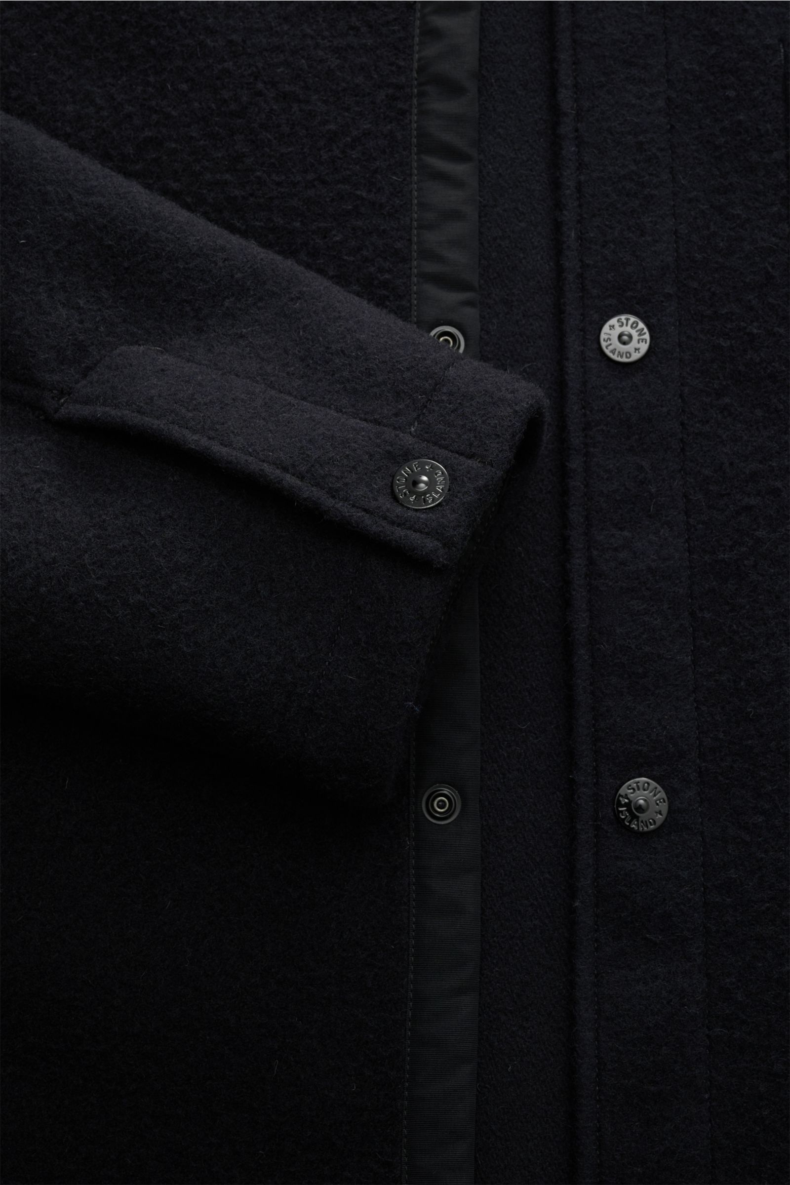 Close-up front view of Stone Island Jacke 'Panno Ratinato' navy, showing the wool and microfiber mix fabric, textured feel, slim fit, snap button placket, turn-down collar, typical compass badge on the sleeve, snap button cuffs, and adjustable hem width.
