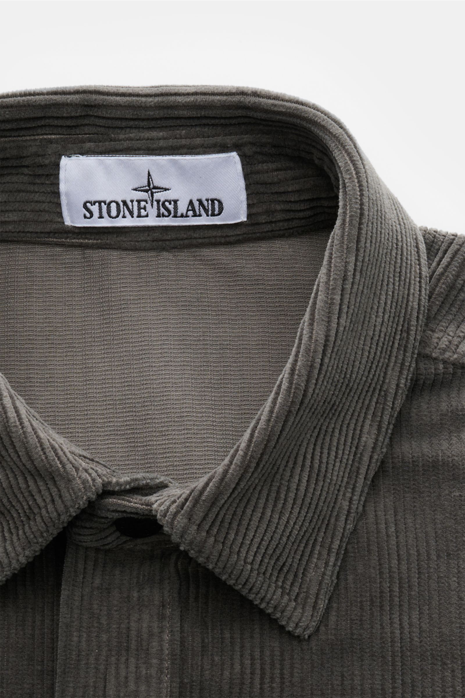 Stone Island Cord Overshirt 'Organic Cotton Corduroy' dunkelgrau, Nahaufnahme von Umlegekragen und Label aus Bio-Baumwollcord.