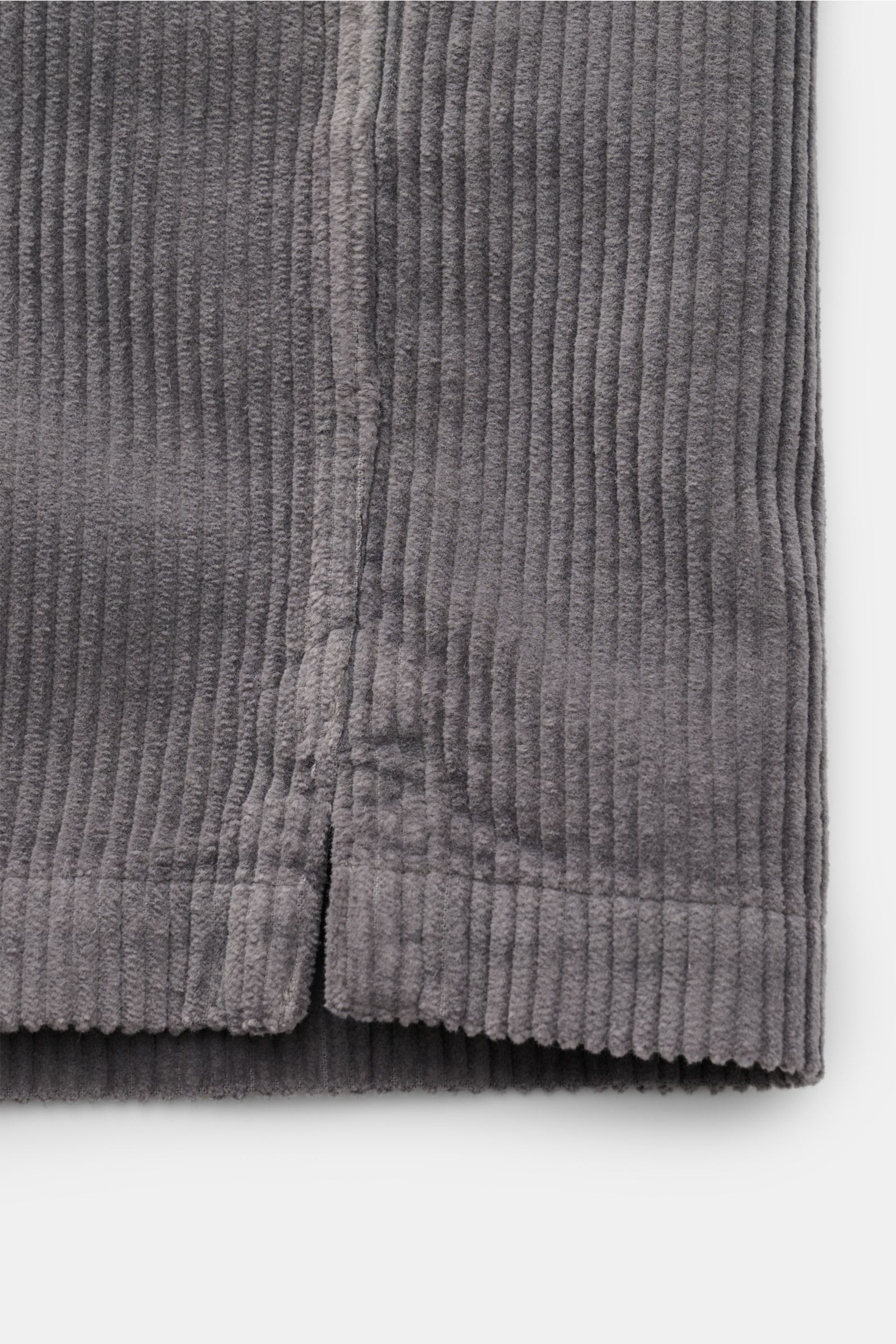 Close-up front view of the hem of the Belstaff Cord-Overshirt 'Fallgate' dunkelgrau, showing dark grey cotton corduroy fabric with short side slits. Cleaner Herbstlook von BELSTAFF: Das Overshirt 'Fallgate' aus robustem Baumwollcord bringt einen modern
