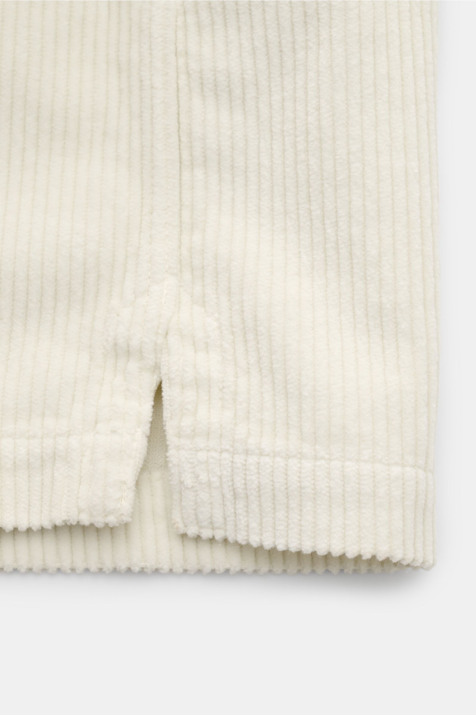 Close-up front view of the hem and short side slit of the Belstaff Cord-Overshirt 'Fallgate' creme in robust cotton cord with ribbed texture.

Cleaner Herbstlook von BELSTAFF: Das Overshirt 'Fallgate' aus robustem Baumwollcord bringt einen modernen Twi