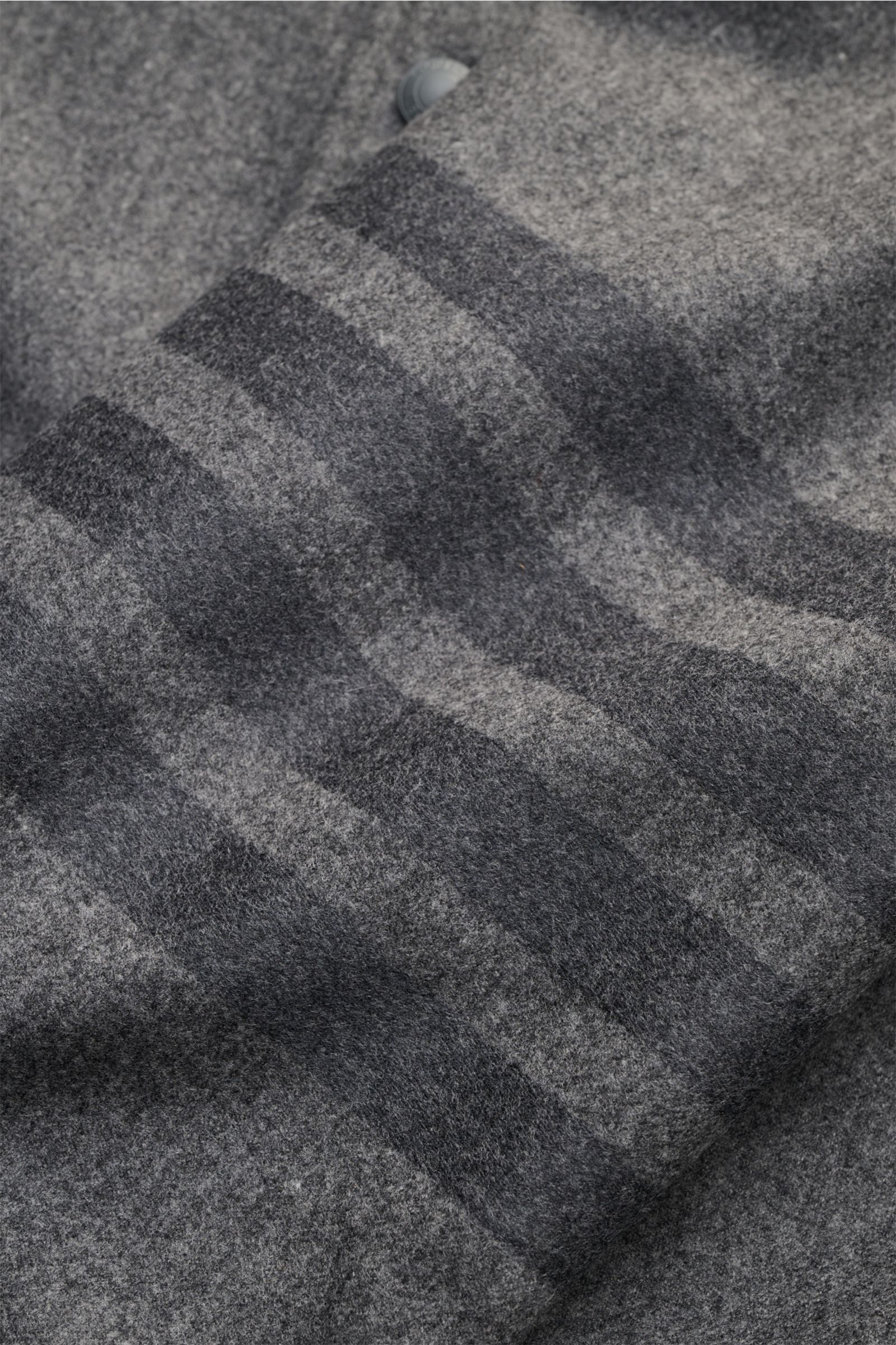 Nahaufnahme des Thom Browne Overshirts dunkelgrau meliert mit softem Griff, tonalen Streifen am Ärmel aus Wolle und Cashmere.