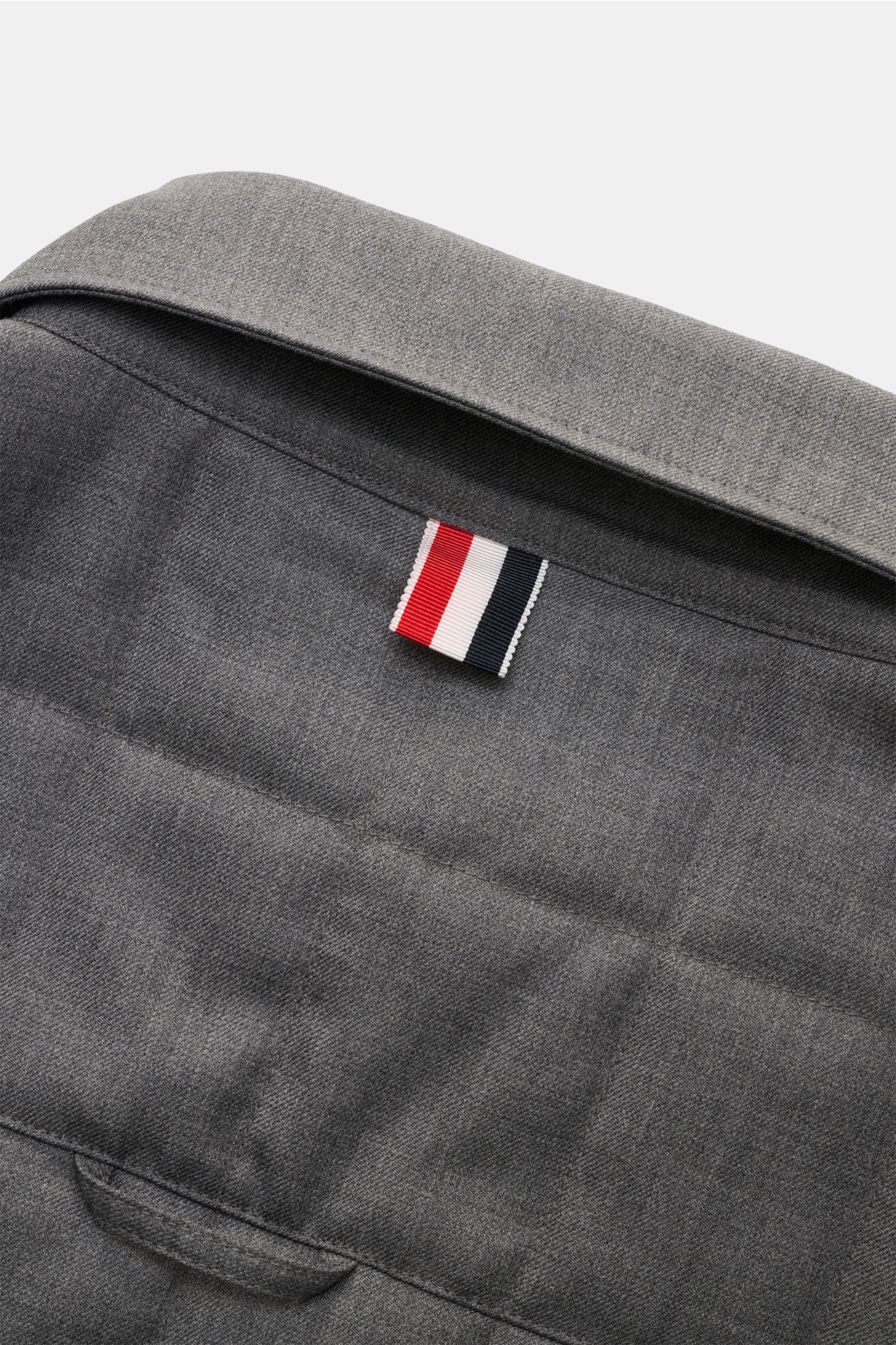 Close-up rear view of Thom Browne Daunenjacke dunkelgrau meliert, showcasing the wool fabric, folded collar, and signature tricolor loop.

Preppy Jacke von THOM BROWNE: Gefertigt aus hochwertiger Wolle mit leichter Daunenfüllung und klassischer Steppun