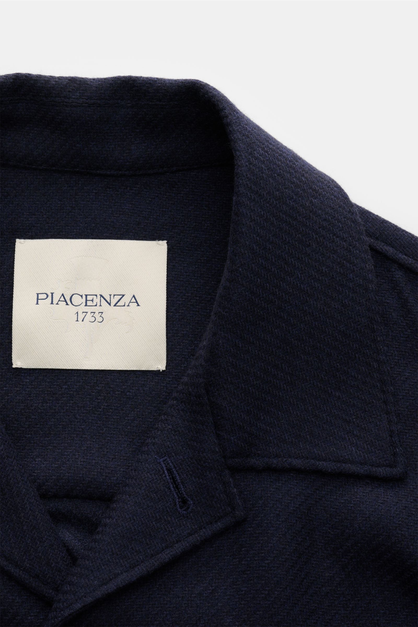 Close-up top-down view of the Piacenza 1733 Overshirt navy collar and label, showcasing its fine woven texture and cashmere-silk blend.

Description: Luxury meets ease: With this casually cut overshirt in a cashmere-silk blend, PIACENZA 1733 brings sma