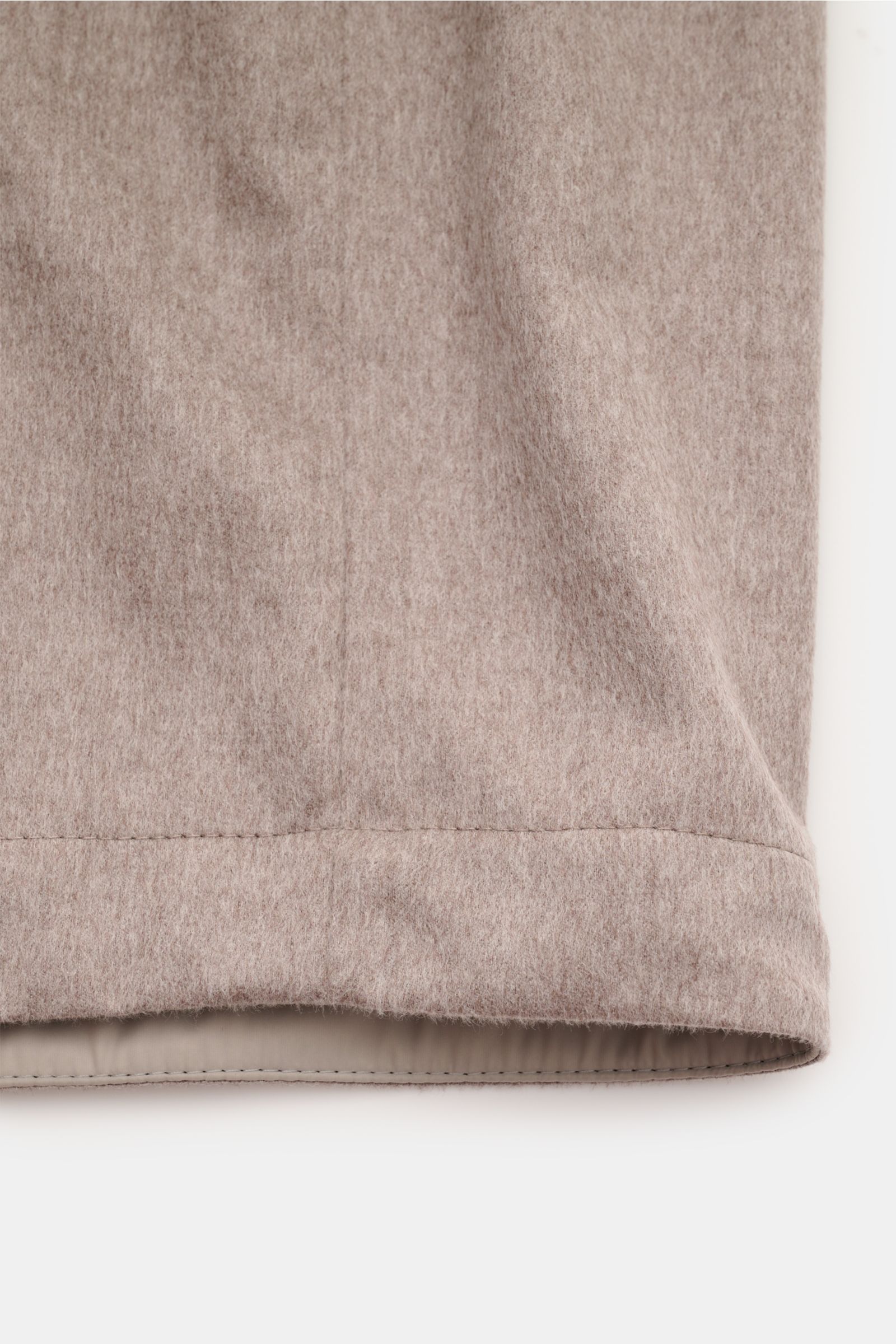 Close-up view of the hem detail of the Brunello Cucinelli Cashmere overshirt sand mottled, showcasing soft pure cashmere fabric with fine stitching and a smooth inner lining.

Timeless classic: This cashmere overshirt by BRUNELLO CUCINELLI offers numer