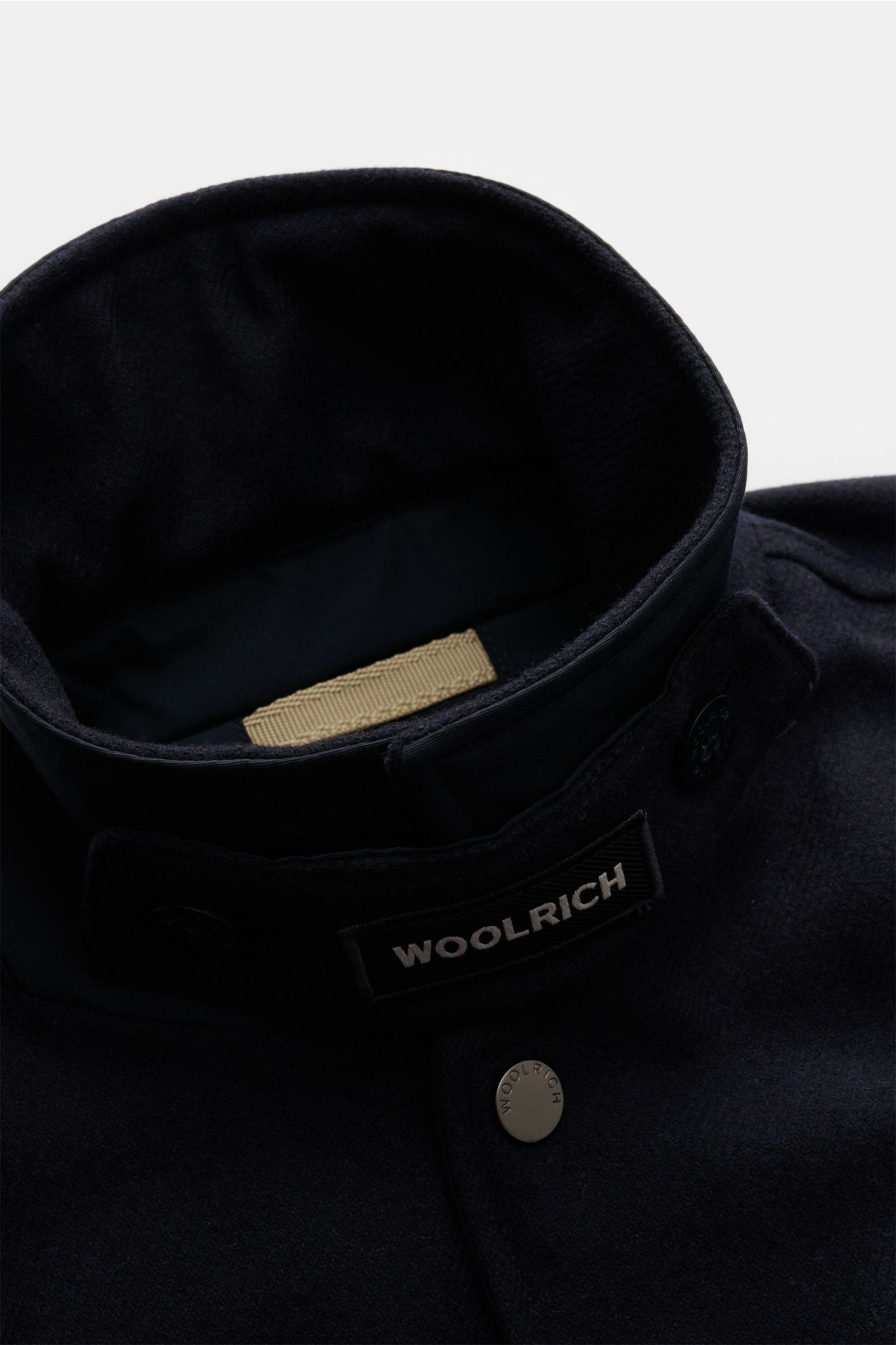 Close-up front top view of Woolrich Daunenjacke navy, showing wool and microfiber fabric, light down filling, slim fit, snap button placket, variable collar with button strap, angled welt pockets, buttoned sleeve cuffs, adjustable waist, quilted smooth li