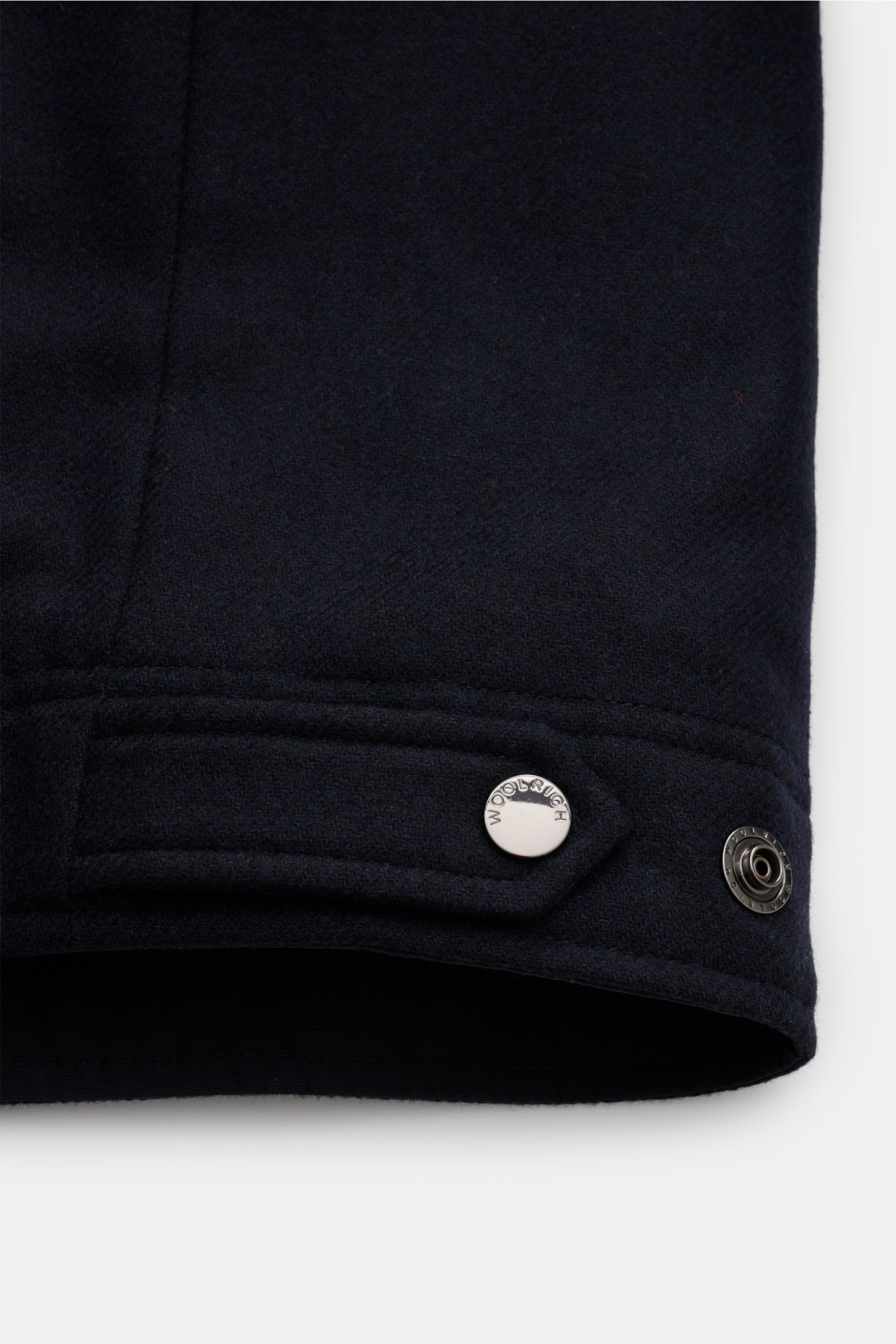 Close-up side view of the sleeve cuff of a Woolrich Daunenjacke navy featuring wool and microfiber, light down filling, slim fit, snap button placket, variable collar with button strap, slanted welt pockets, buttoned sleeve cuffs, adjustable waist, quilte