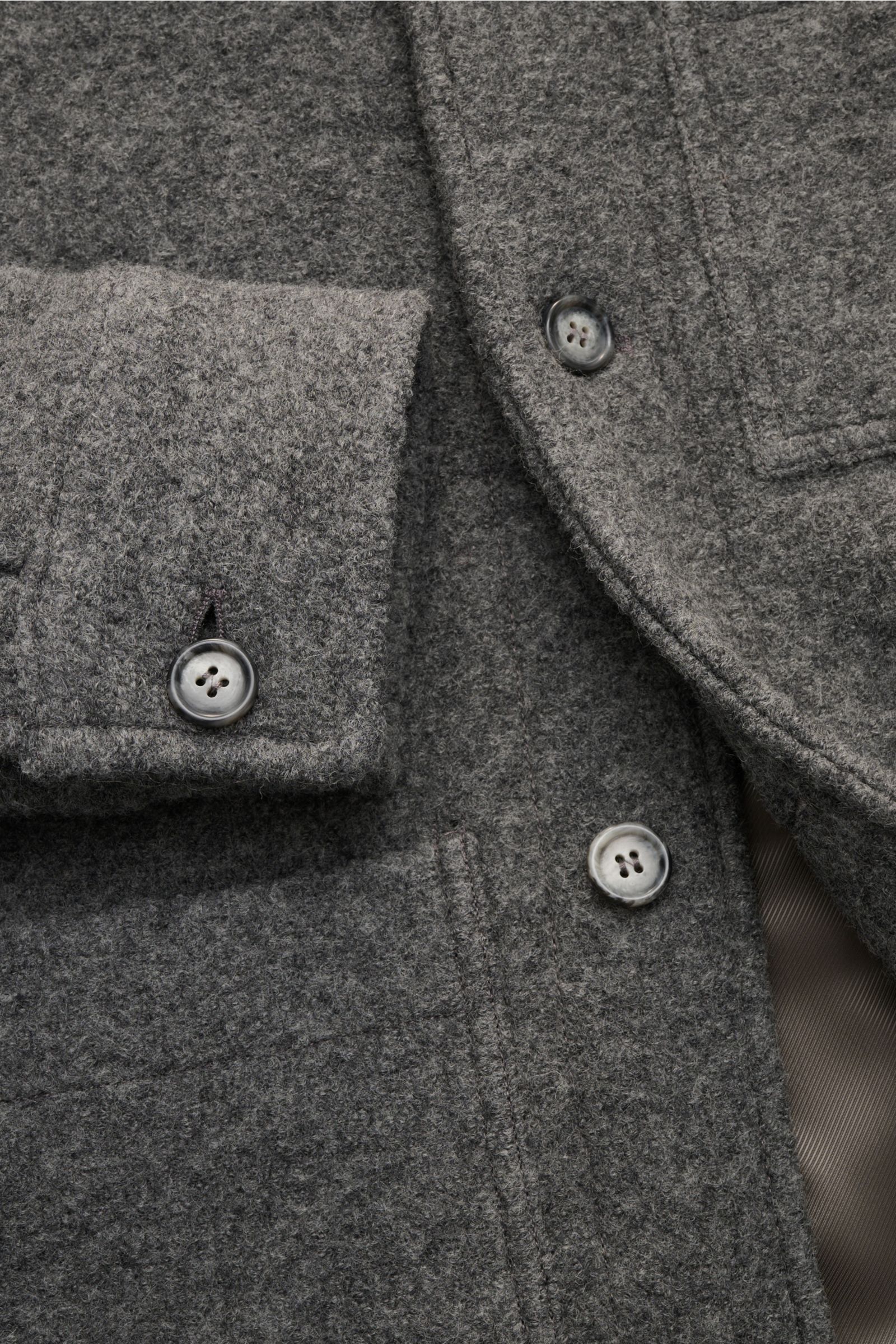 Close-up front view of the A.P.C. Bouclé-Overshirt 'Emile' dunkelgrau showing dark gray wool boucle fabric, button details, cuff, and layered chest and hip pockets.

Anziehen, wohlfühlen, cool aussehen: Das Overshirt 'Emile' von A.P.C. aus Woll-Bouclé 