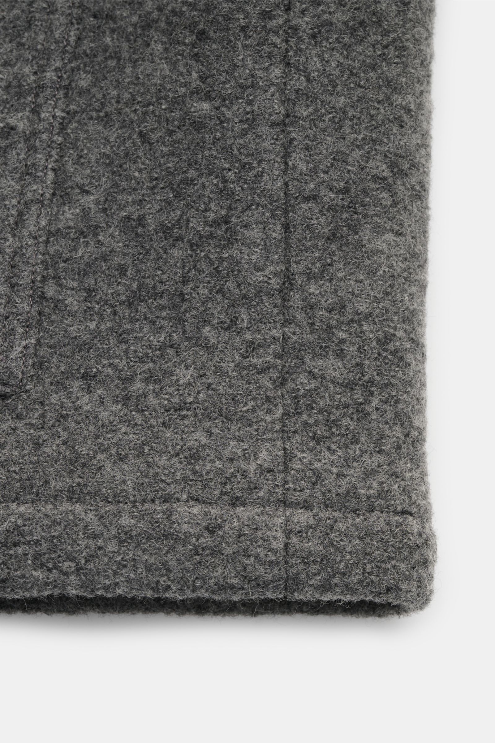 Close-up front view of the textured fabric and stitching details of the A.P.C. Bouclé-Overshirt 'Emile' dunkelgrau in dark gray wool bouclé, featuring a heavy, grippy quality and light padding. Anziehen, wohlfühlen, cool aussehen: Das Overshirt 'Emile'
