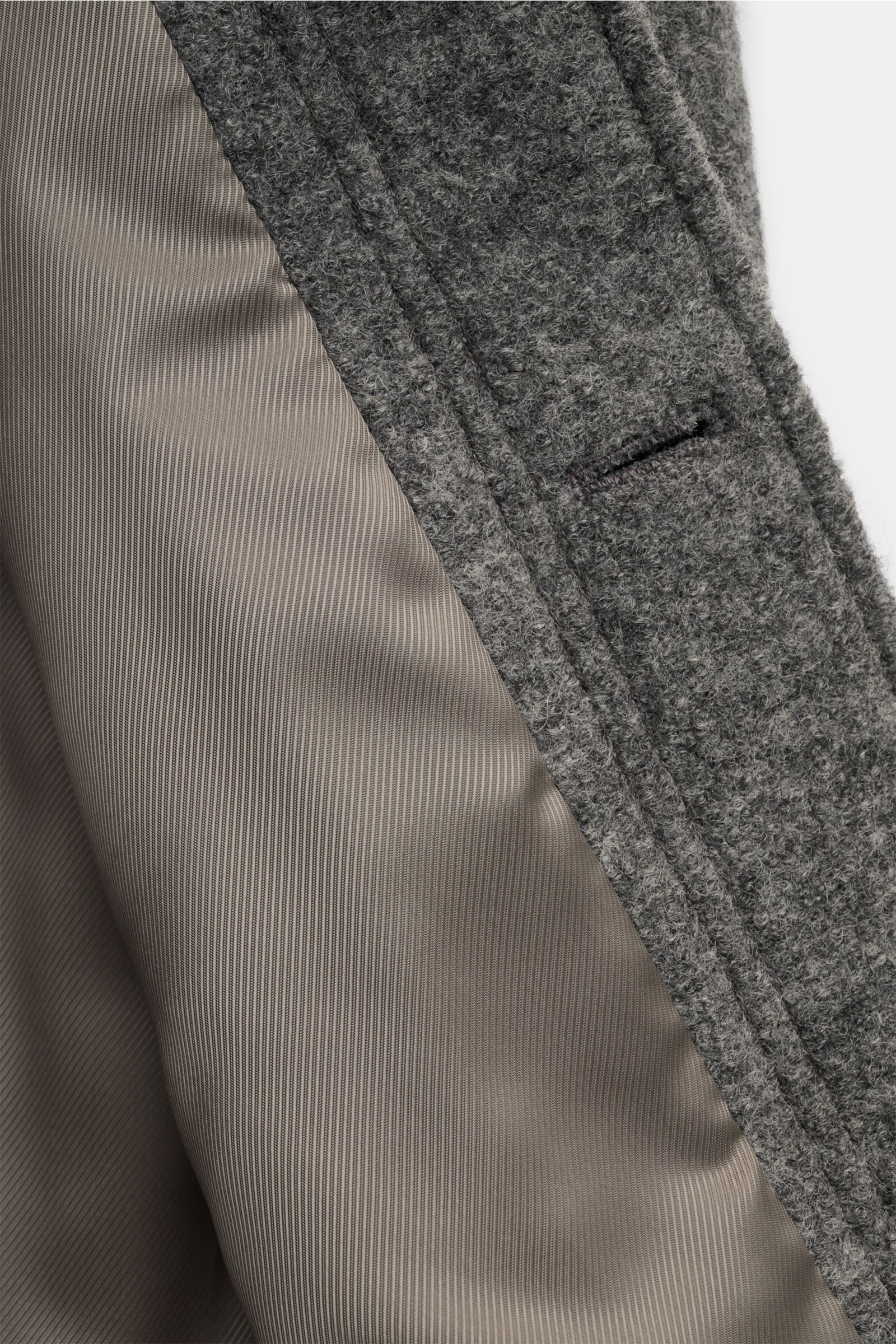 A close-up front-side view of the A.P.C. Bouclé-Overshirt 'Emile' dunkelgrau, showing its textured dark grey wool bouclé fabric and smooth, tonal lining. Anziehen, wohlfühlen, cool aussehen: Das Overshirt 'Emile' von A.P.C. aus Woll-Bouclé ist der ideale 