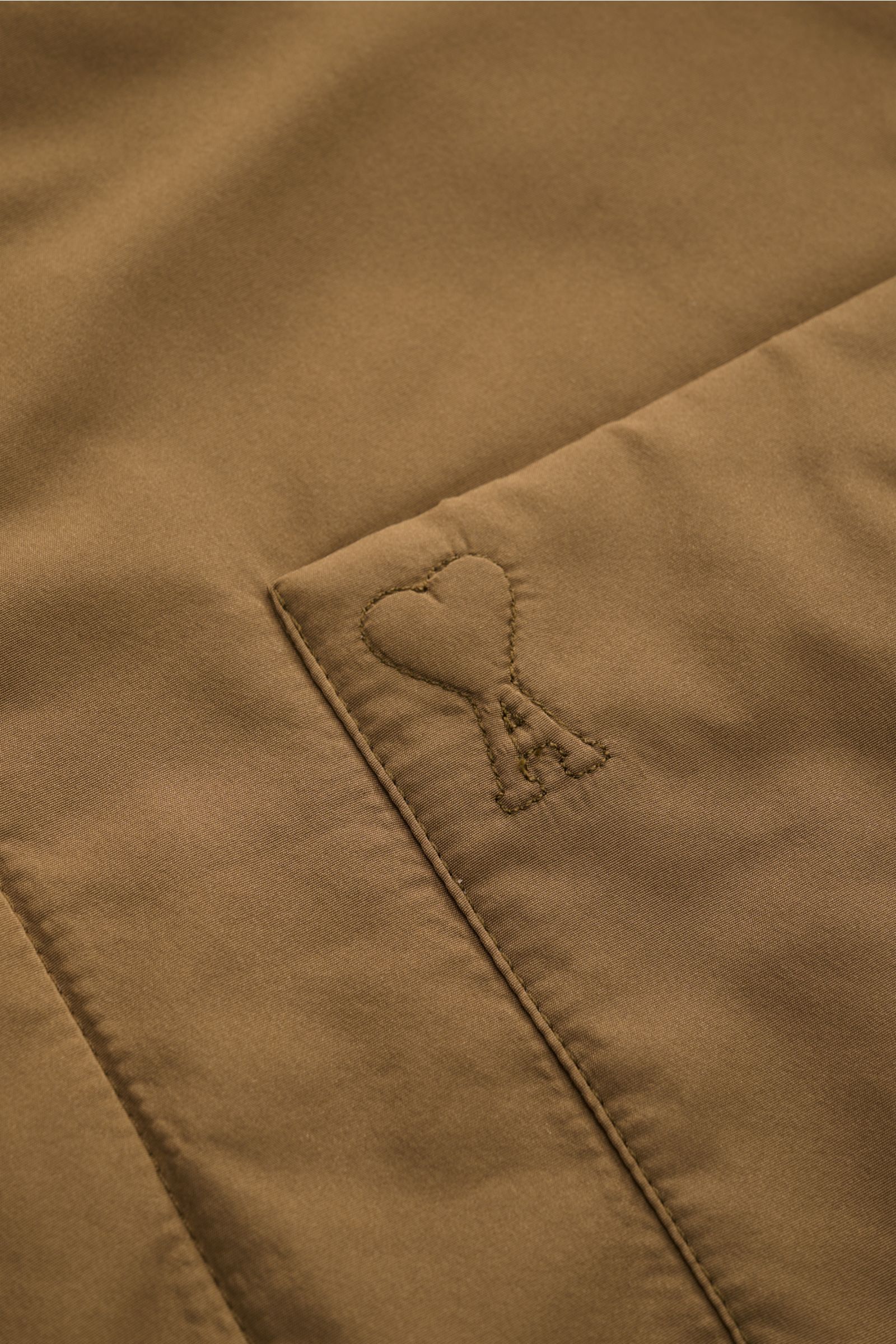 Nahaufnahme des Ami Paris Overshirt graubraun mit hochwertiger Microfaser, glattem Griff und tonalem Herz-Stick auf der Brusttasche.