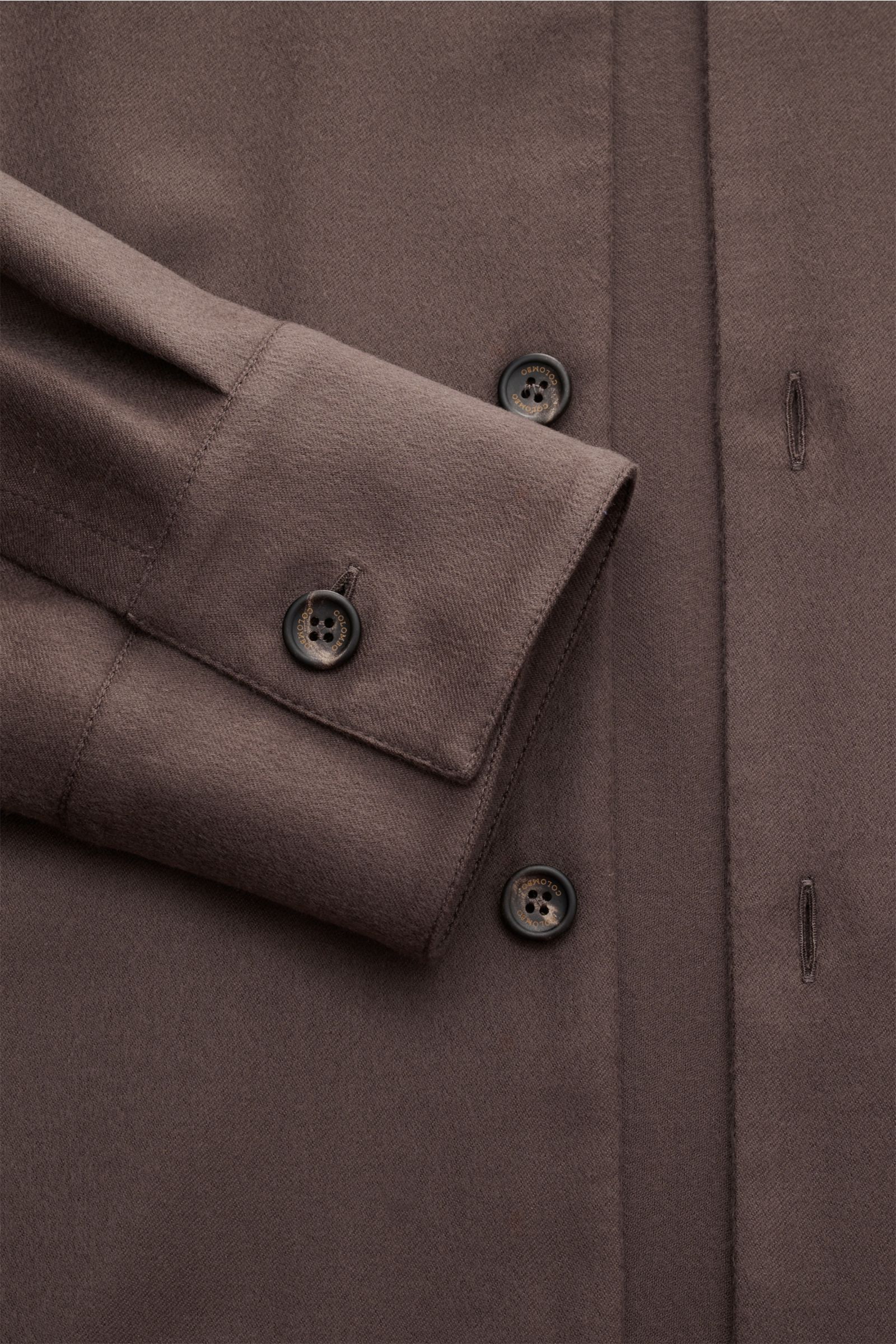 Nahaufnahme des Colombo Cashmere Overshirt graubraun von oben, zeigt Slim Fit, reinen Cashmere, sehr weichen Griff, Sechs-Knopf-Leiste, Umlegekragen, klassische Sportmanschette, ungefüttert, versteckte Seitentaschen und zwei Innentaschen.