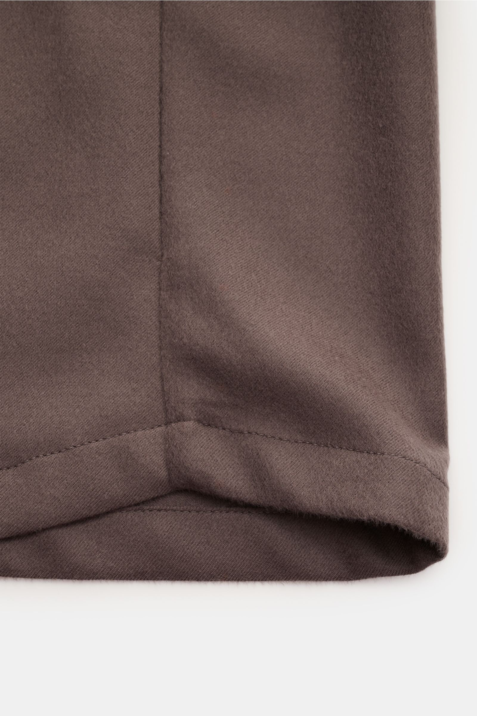 Nahaufnahme des unteren Saums des Colombo Cashmere Overshirt graubraun, reiner Cashmere, weicher Griff, Slim Fit, sechs-Knopf-Leiste, Umlegekragen, versteckte Taschen, klassische Sportmanschette, ungefüttert, zwei Innentaschen, Seitenansicht.