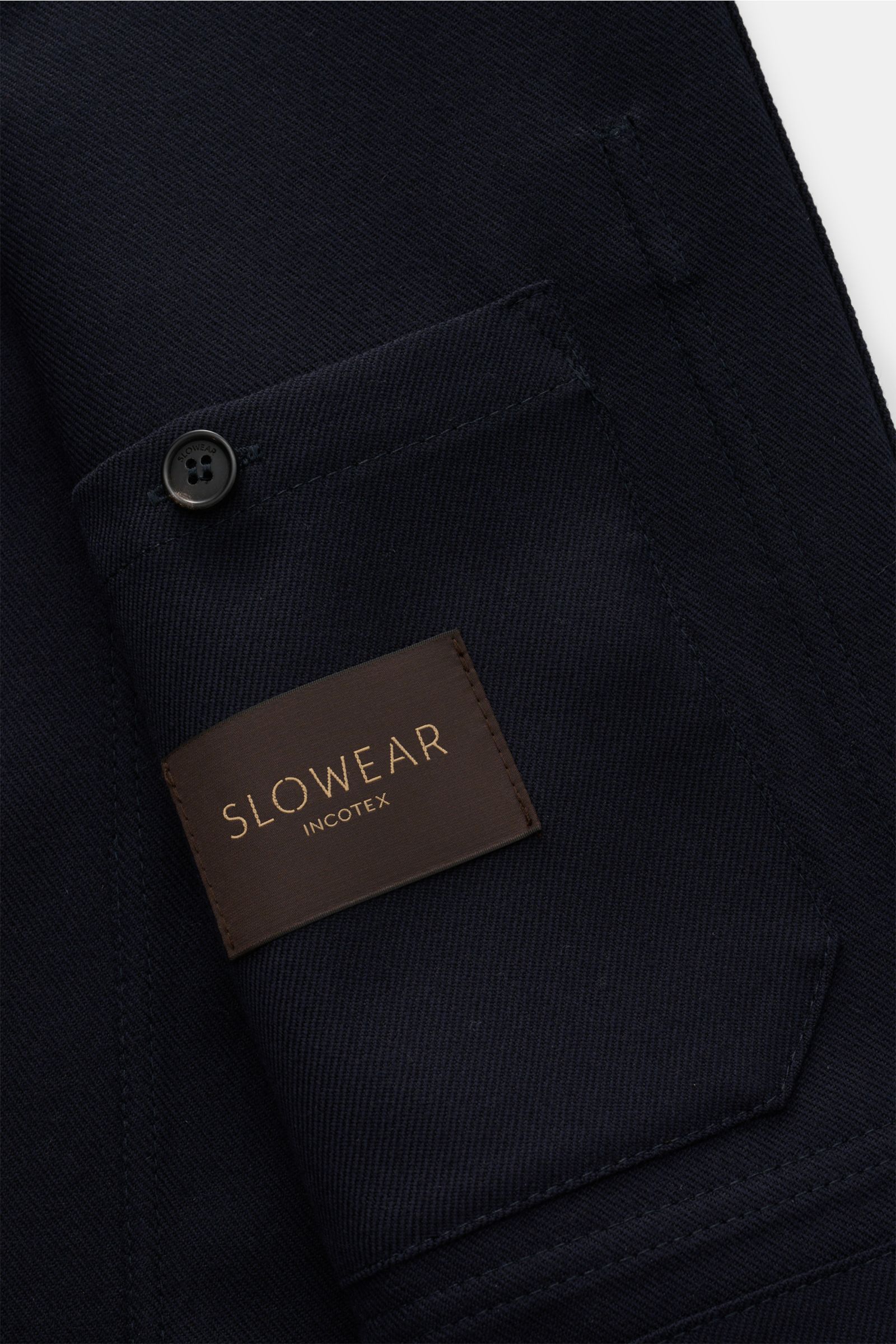 Close-up view of the Incotex Overshirt navy sleeve pocket with button and SLOWEAR label, showing wool-cashmere fabric texture.

Description: Wenn die Grenzen zwischen Hemd und Jacke verschwimmen, entsteht mit dem Overshirt aus Schurwolle und Cashmere v