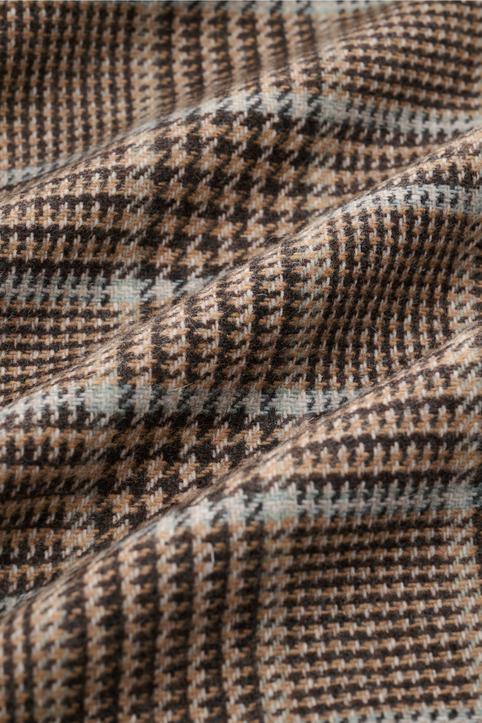Close-up fabric detail photo of the 04651/ A trip in a bag Overshirt schwarz/rauchblau/hellbraun kariert, showing the soft wool-mix material with classic Glencheck pattern. The image highlights the texture and weave from a top-down perspective. Das perfek
