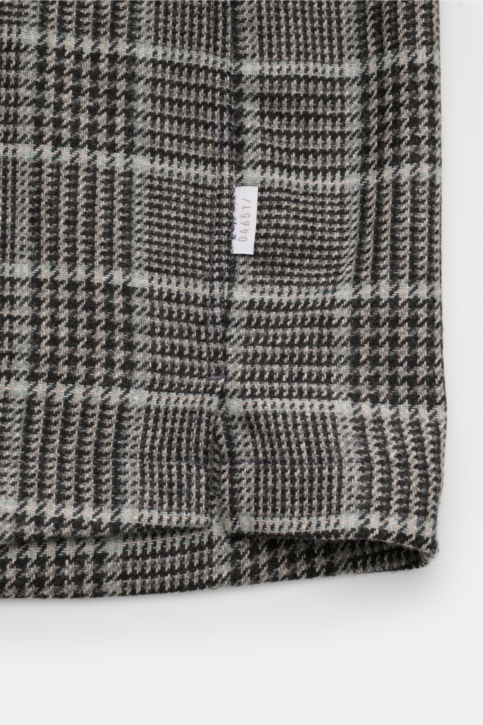Close-up front hem view of 04651/ A trip in a bag Overshirt schwarz/grau kariert in classic Glencheck, wool-mix fabric, soft touch, slim fit with logo label.

Description: Das perfekte Styling-Piece für Ihre Freizeitgarderobe: Das karierte Overshirt vo