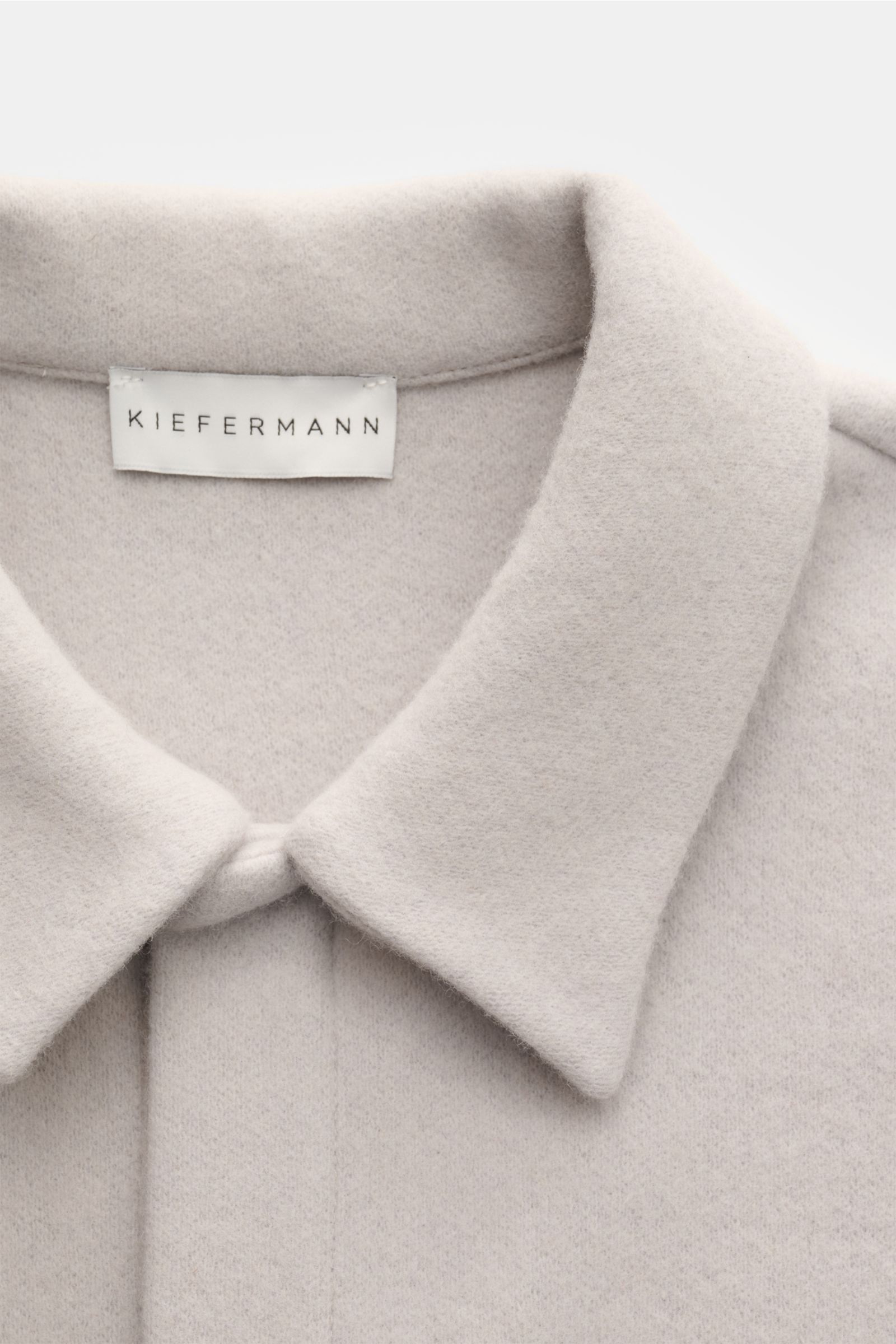 Close-up front view of the Kiefermann Overshirt 'Elijaz' hellgrau showing the soft, light grey wool and microfiber jersey with a smooth texture, featuring a concealed snap-button placket and an unfolded collar. Jersey aus Wolle und hochwertiger Microfaser