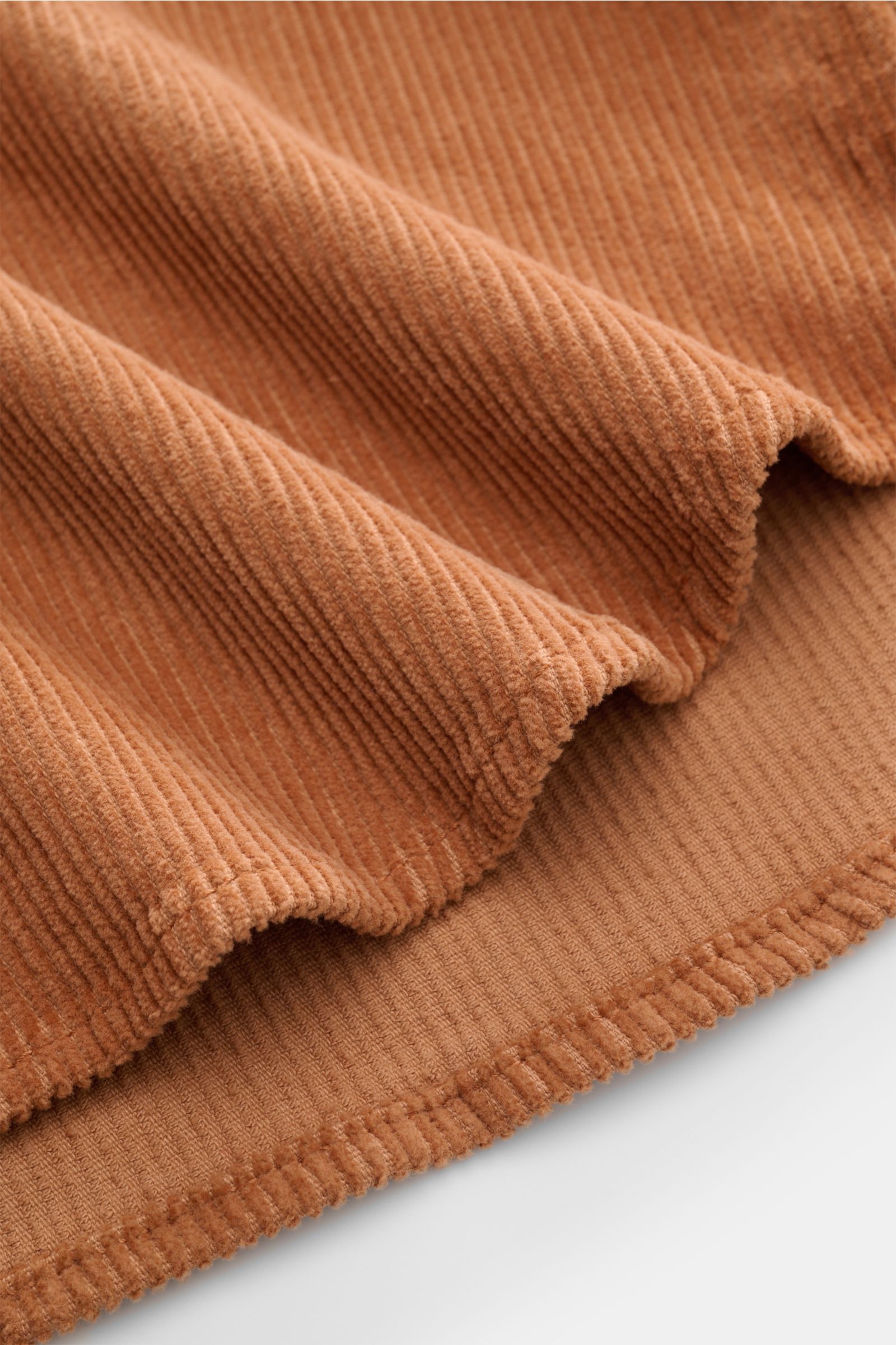 Nahaufnahme des weichen, hellbraunen Ace Denim Cord-Overshirts aus reiner Baumwolle, Detail der Cordstruktur und Saumkante.
