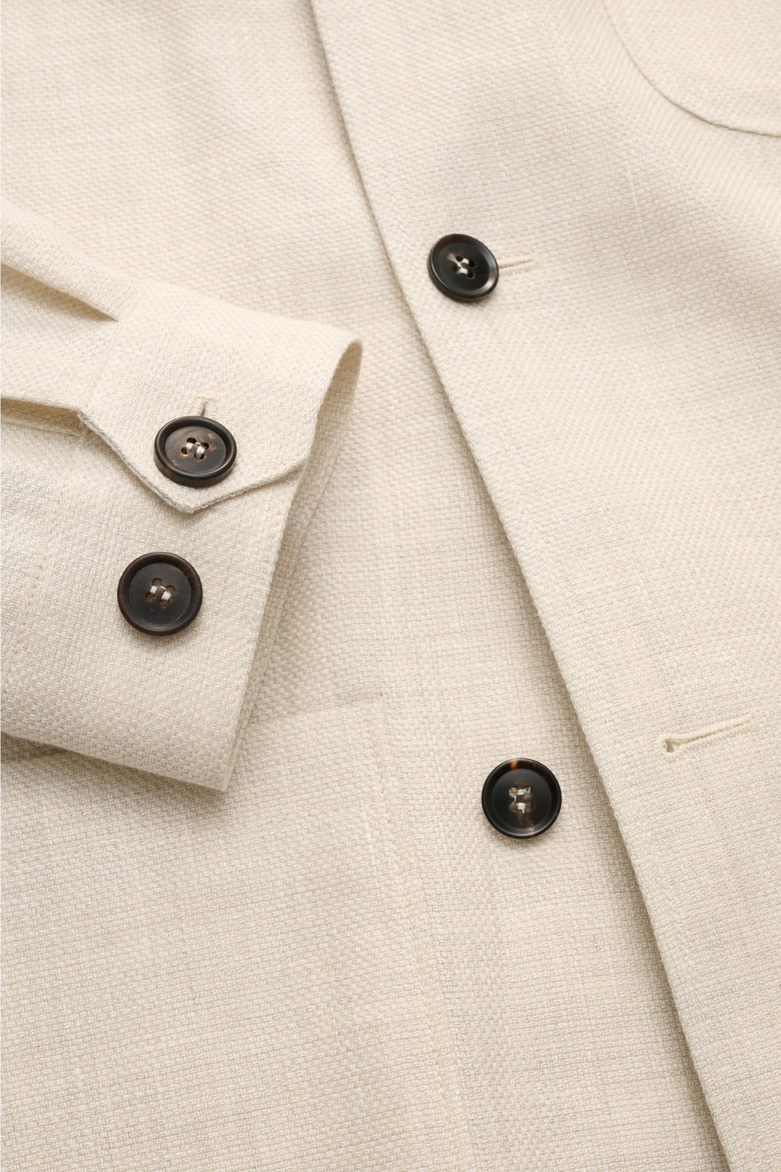 Close-up front view of the Corneliani Overshirt sand mottled showing textured linen and wool fabric with dark buttons, cuffs, and patch pockets.

This overshirt in linen and wool by CORNELIANI is an elegant shirt-jacket hybrid and enhances a variety of