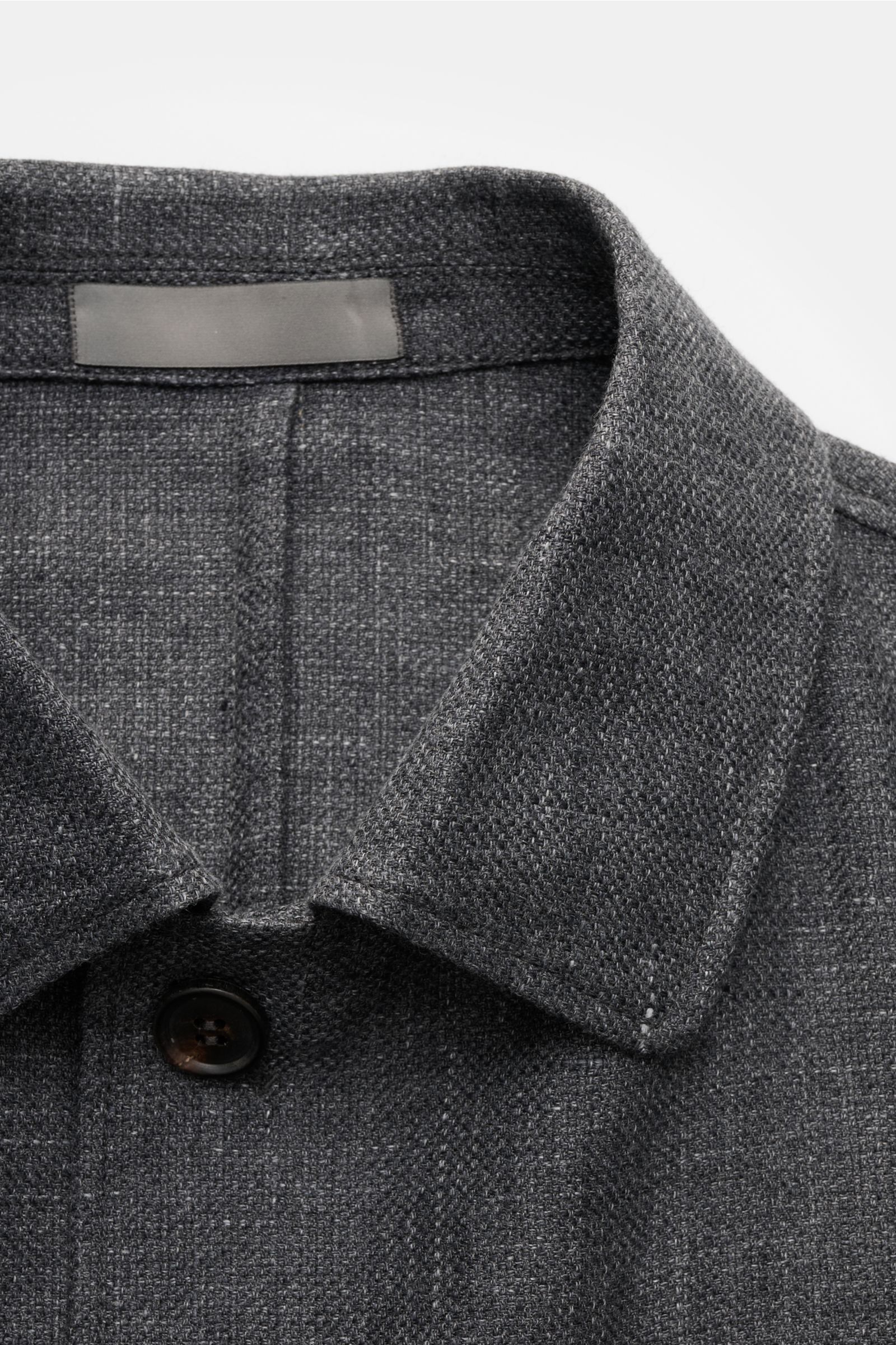 Corneliani Overshirt dunkelgrau meliert, Nahaufnahme von Hemdkragen, Panama aus Leinen und Wolle, weicher Griff, Slim Fit, Vier-Knopf-Leiste, Manschetten, Seitenschlitze.