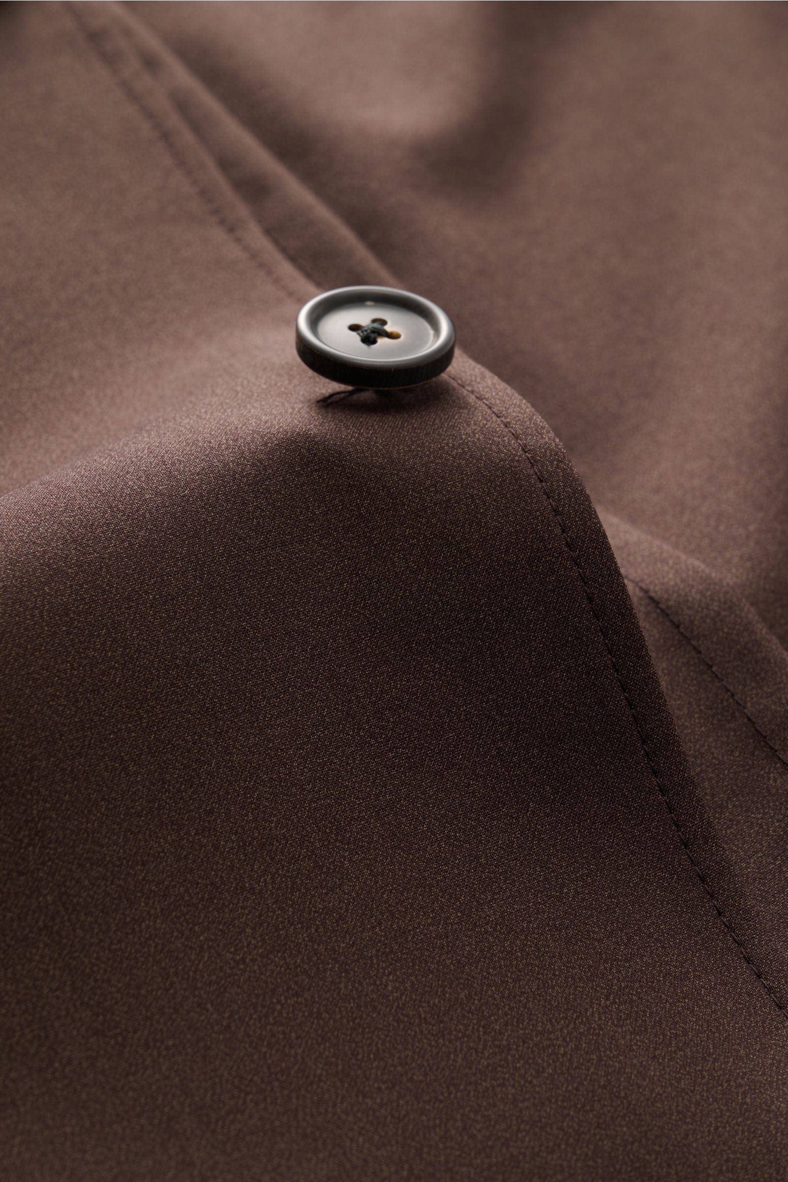 Corneliani Overshirt dunkelbraun aus Schurwoll-Seidenqualität, Detailaufnahme Knopf und glatter Griff, Slim Fit, fallendes Revers sichtbar.