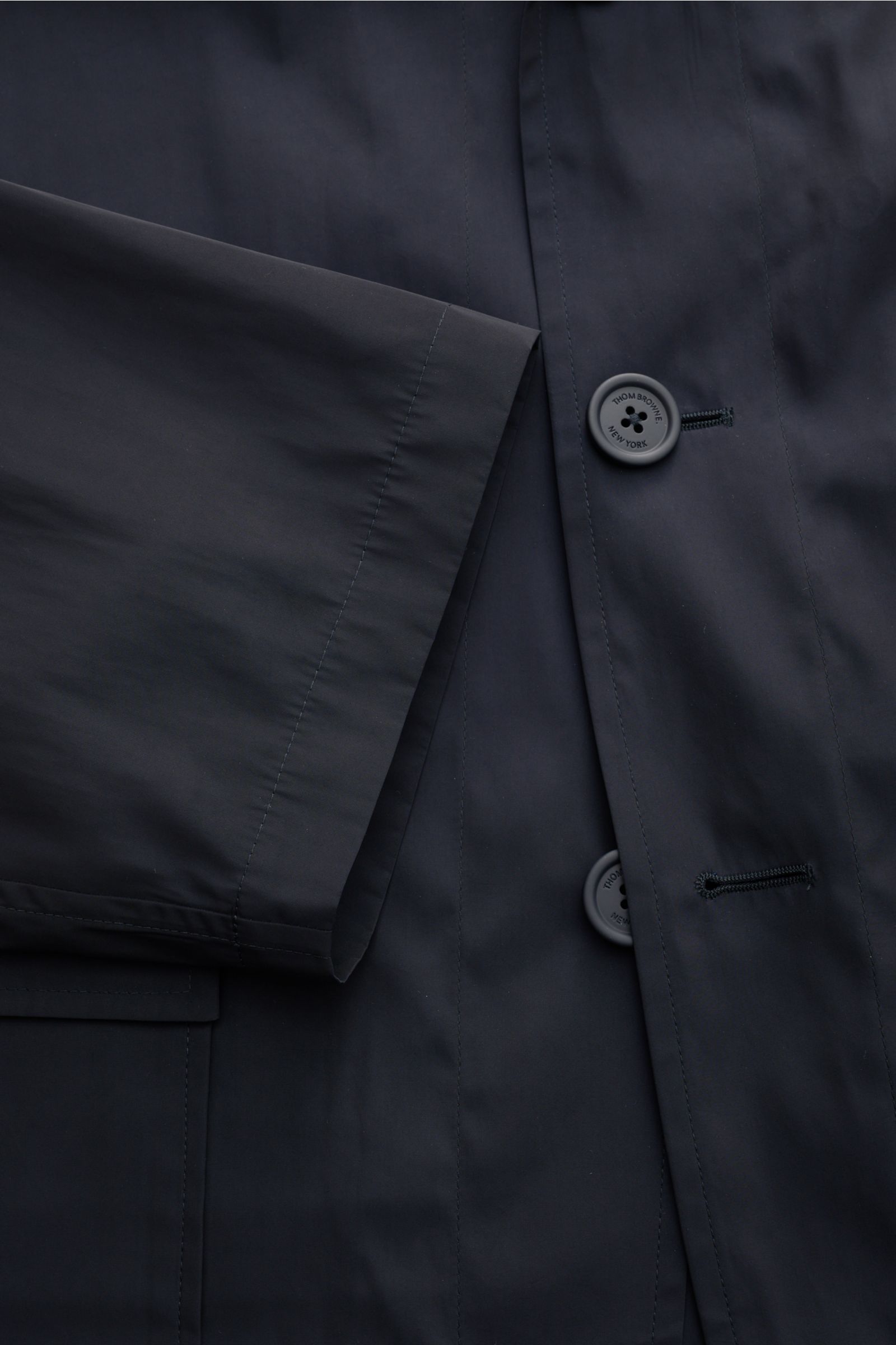 Thom Browne Overshirt navy aus glatter Microfaser, Regular Fit, vier-Knopf-Leiste, variabler Kragen, Front- und Innentaschen, Detailaufnahme von vorne.