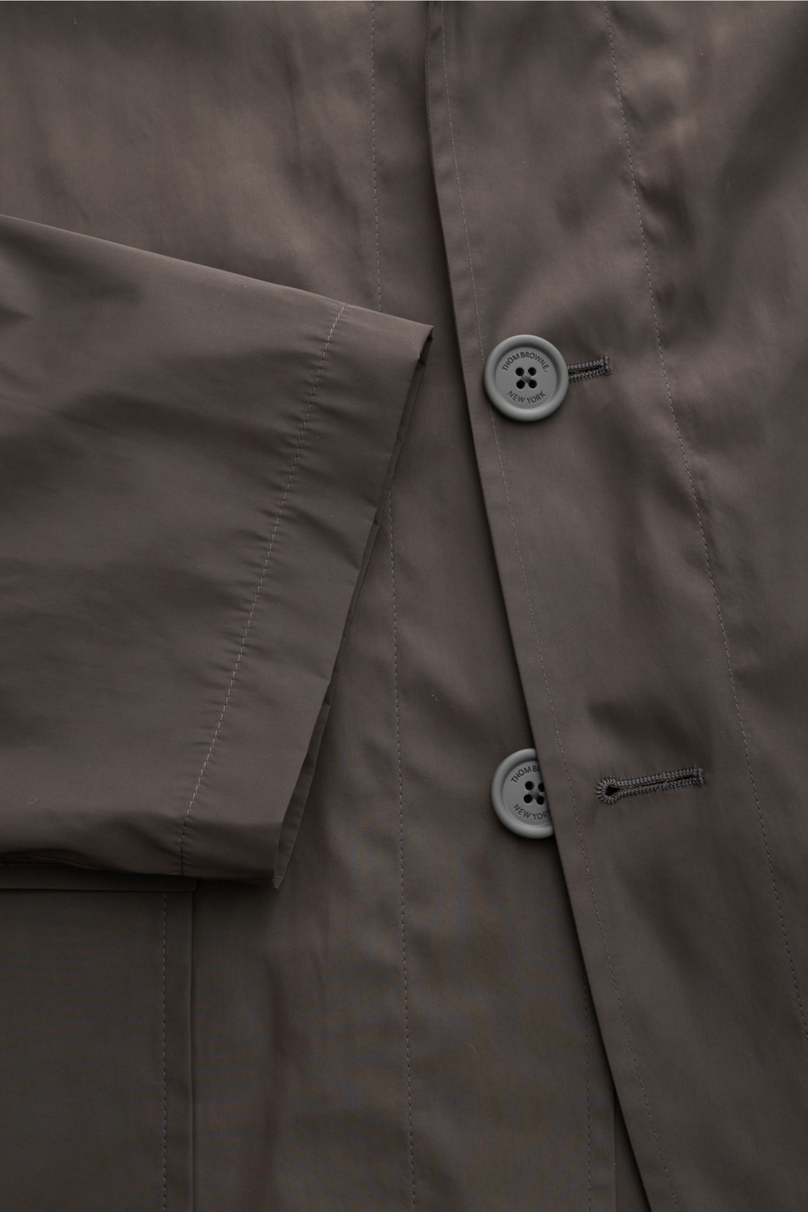 Thom Browne Overshirt anthrazit aus hochwertiger Microfaser mit glattem Griff, Vier-Knopf-Leiste und aufgesetzten Fronttaschen, Nahaufnahme von vorne.