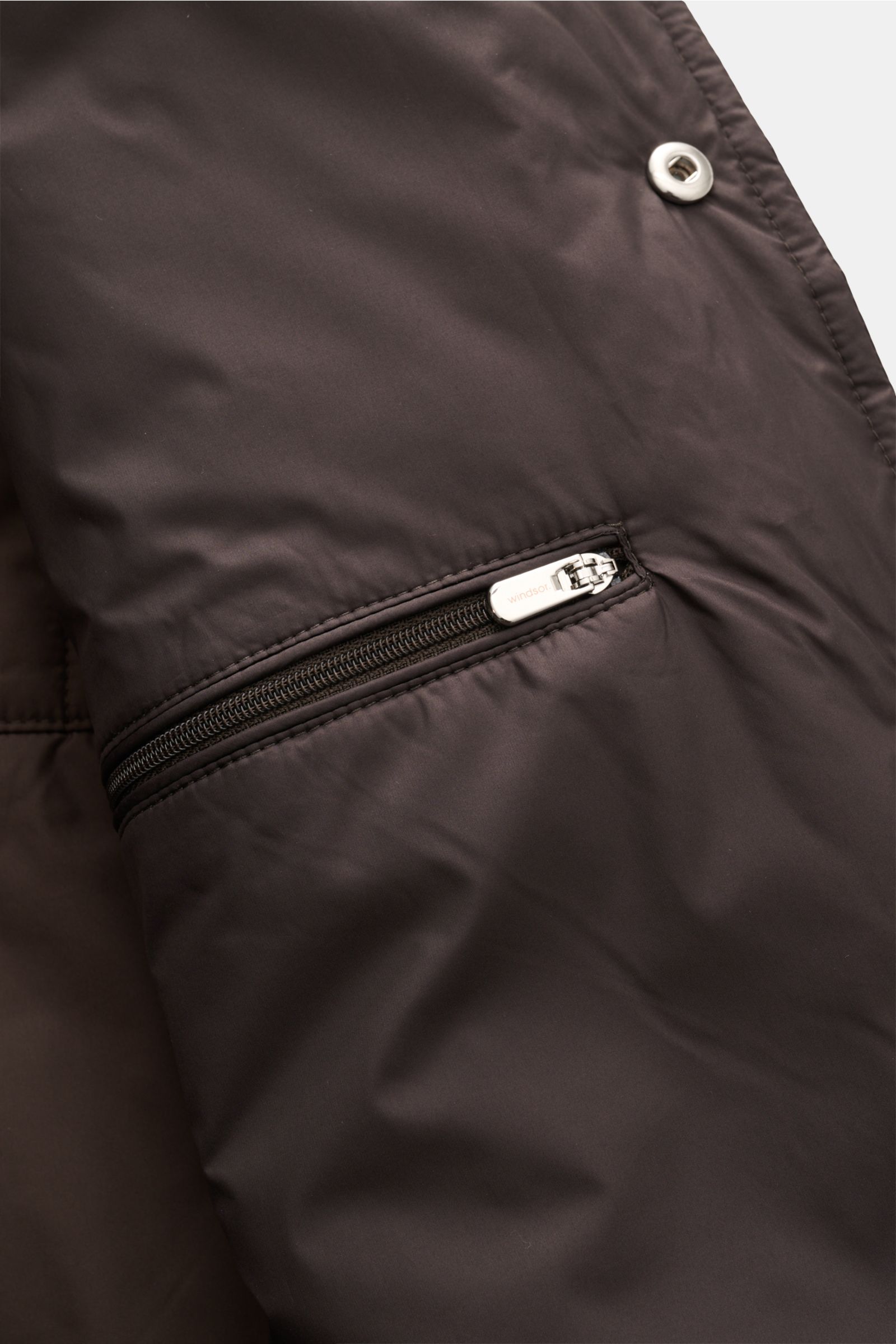 Close-up view of the interior zipper pocket of the Windsor Overshirt 'Paride' dunkelbraun, showcasing smooth microfiber fabric and snap button details, designed for comfort and style in transitional seasons. Stilvoller Begleiter für die Übergangssaison: D